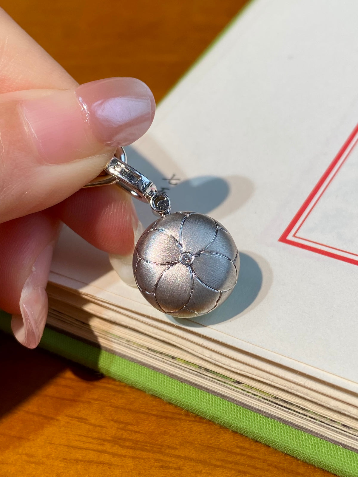 Silver necklace with green jadeite donut pendant, chain links visible