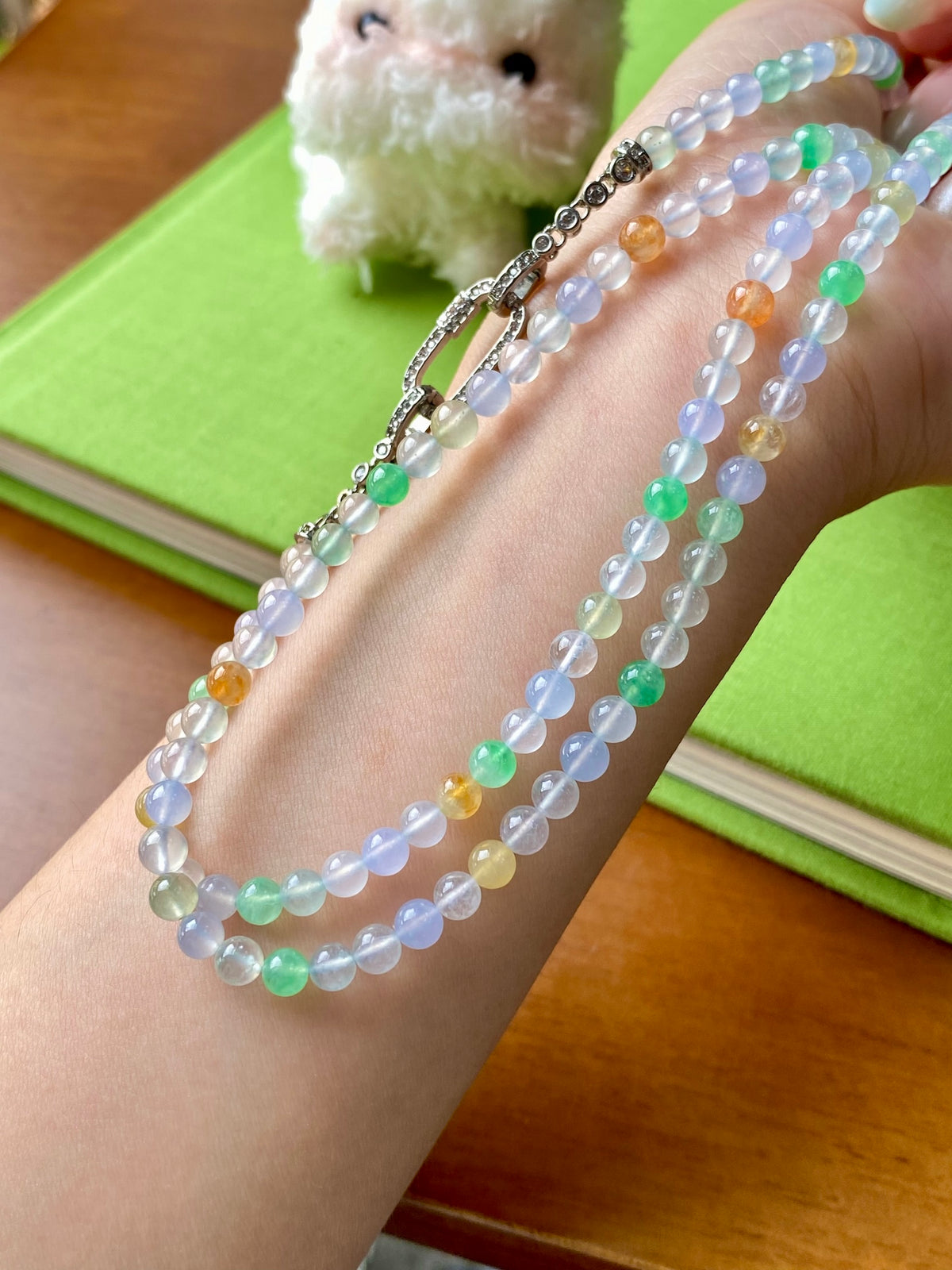 Multi-strand beaded necklace with light blue and green beads plus orange accents, toggle clasp