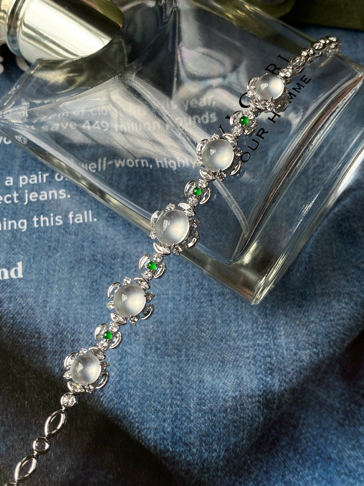 Silver-tone cabochon bracelet with icy white ovals and tiny green gems along the chain