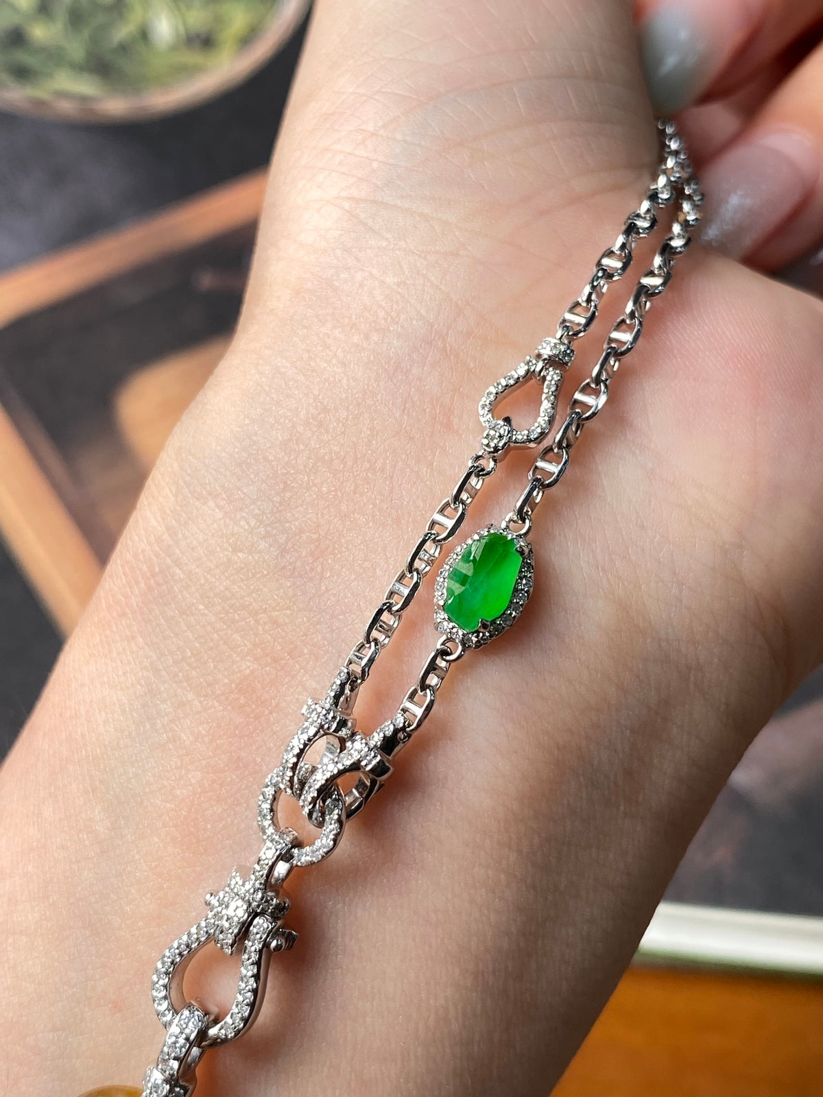 Silver-tone chain necklace with green oval gemstone pendant and sparkling end links