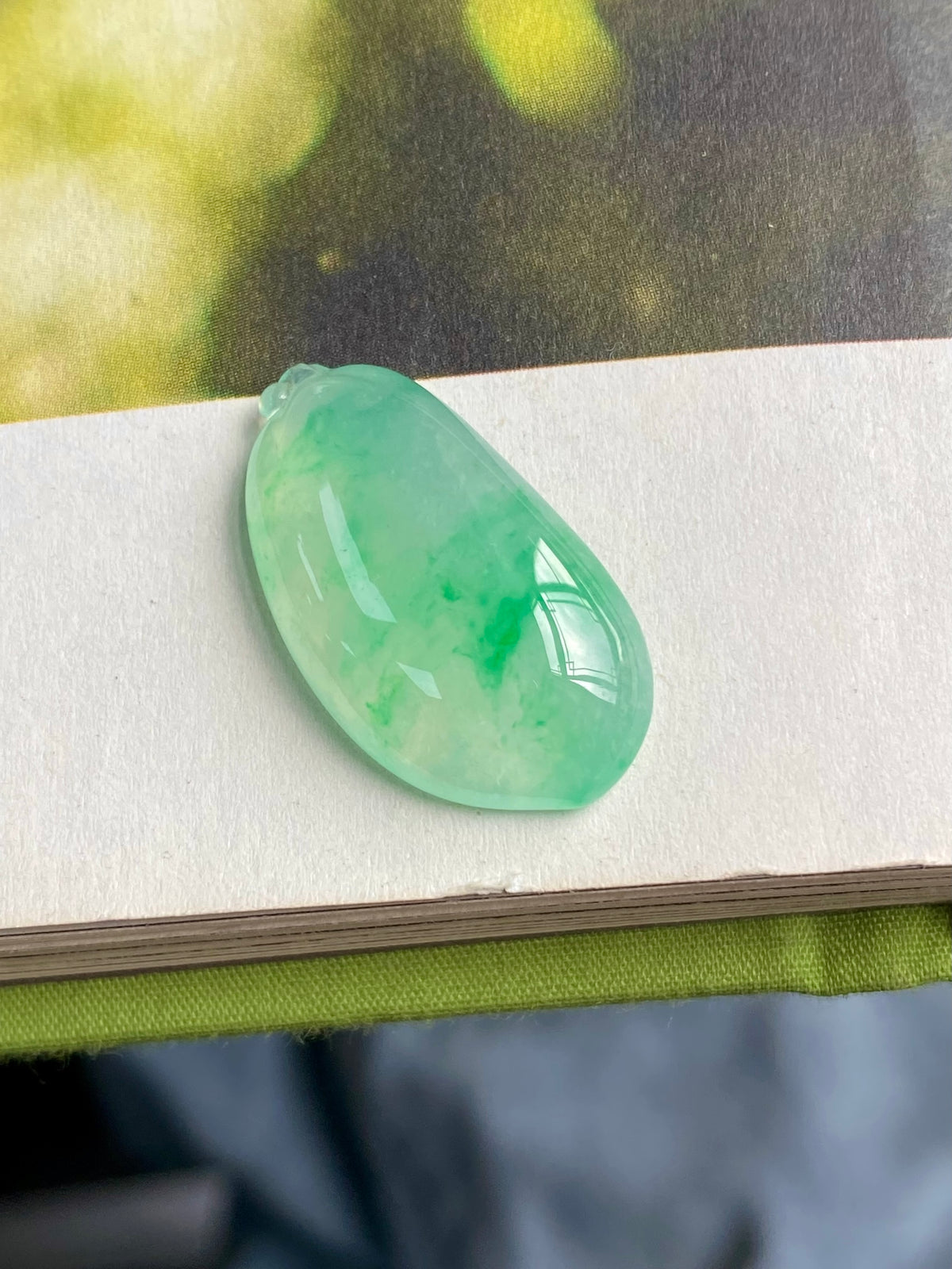 Jadeite melon pendant, translucent light green teardrop with silver-tone loop at top