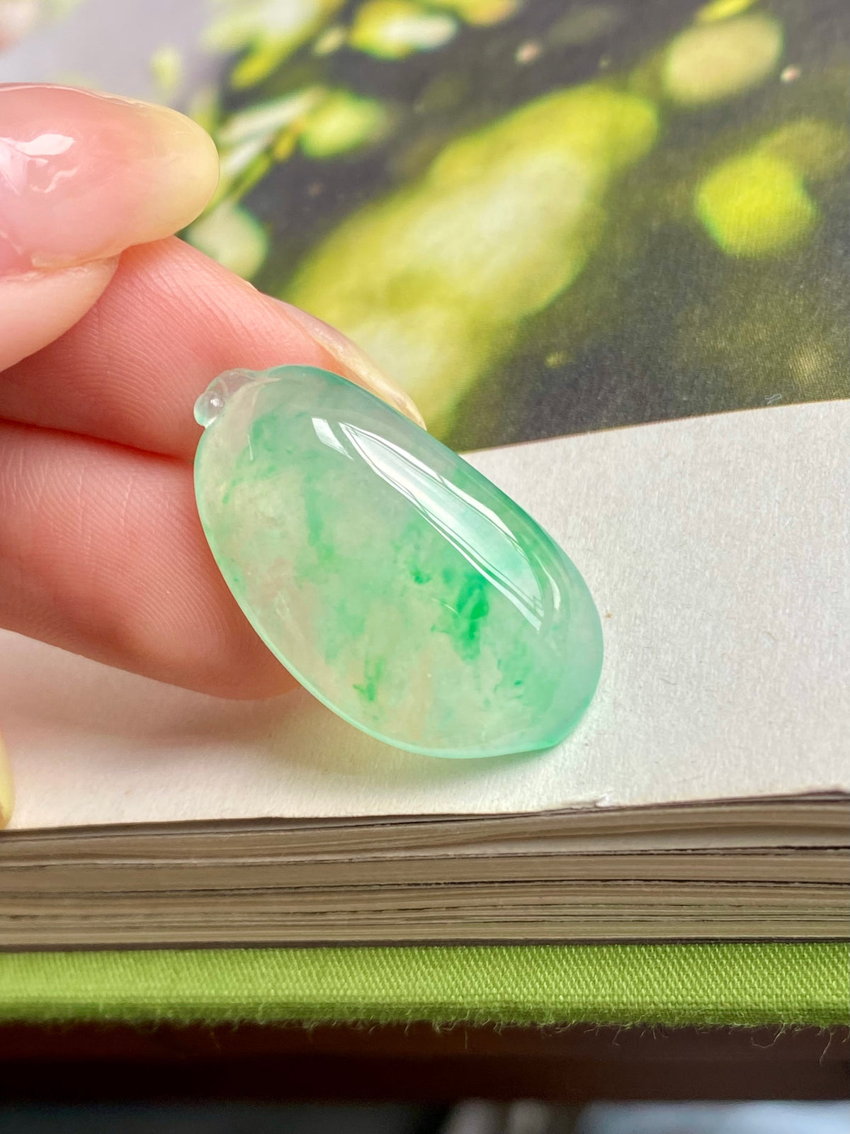 Light green jadeite melon pendant detail, teardrop with glossy carved texture