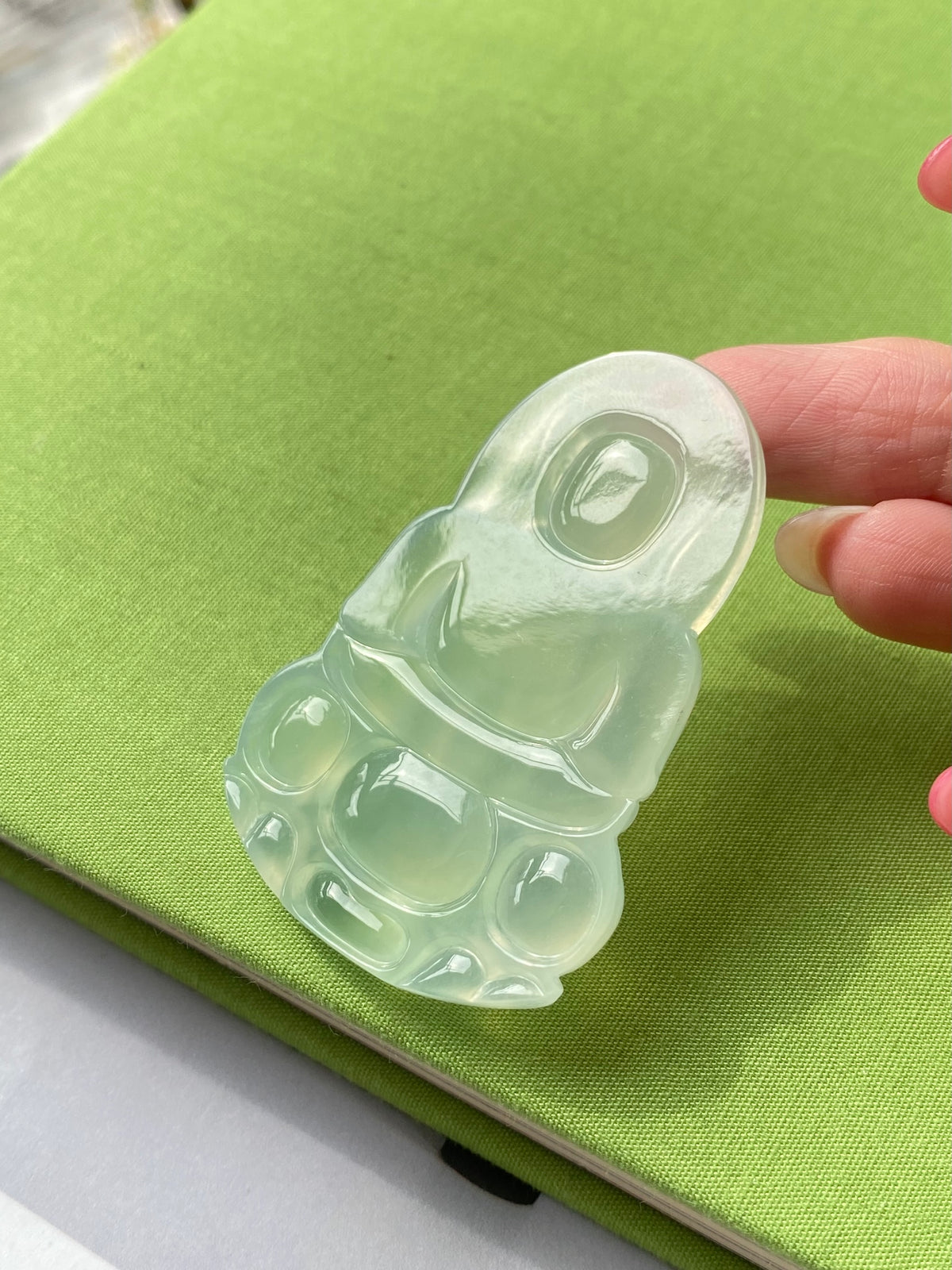 Light green translucent Guanyin jade pendant with detailed face and halo