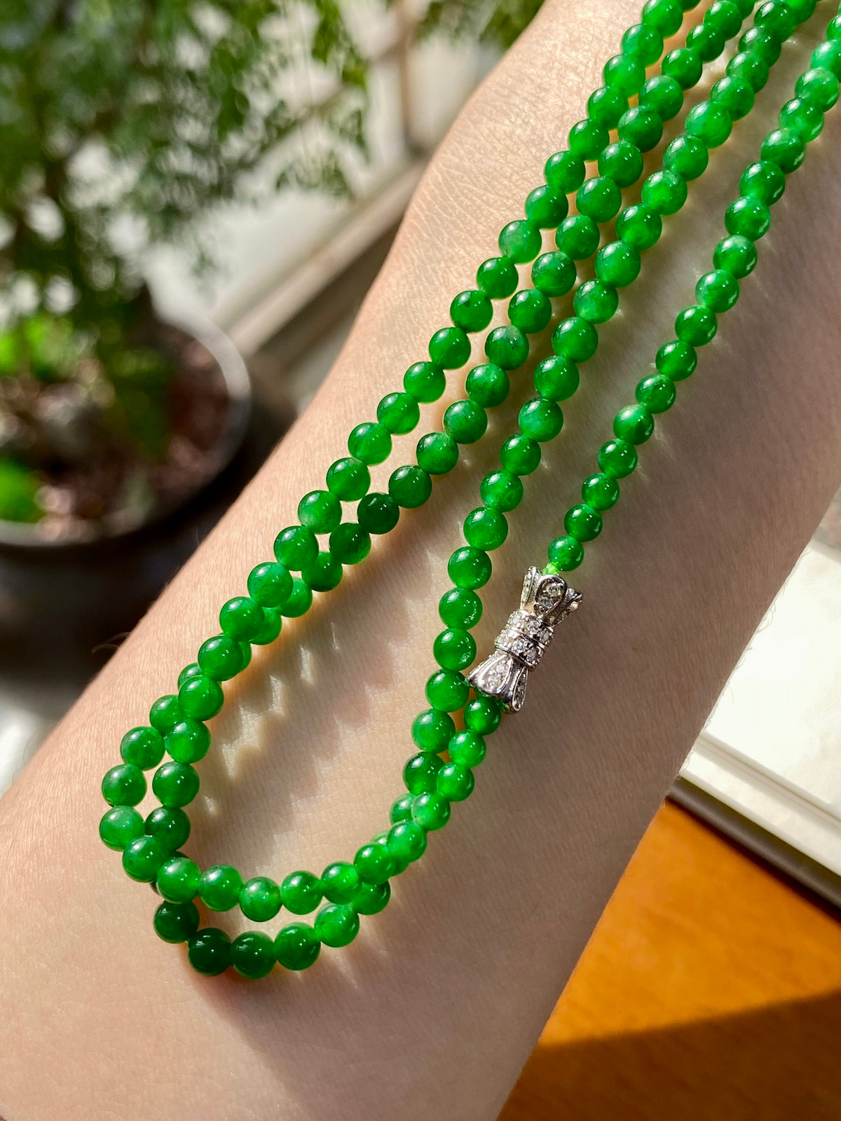 Green jadeite beaded necklace with multi-strand loop and silver clasp with stone