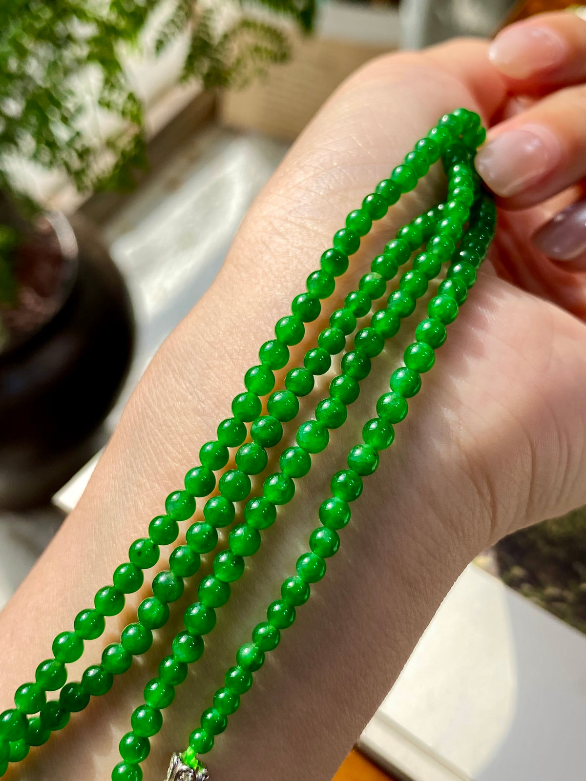 Green jadeite beaded strands with glossy round beads, layered loop close-up