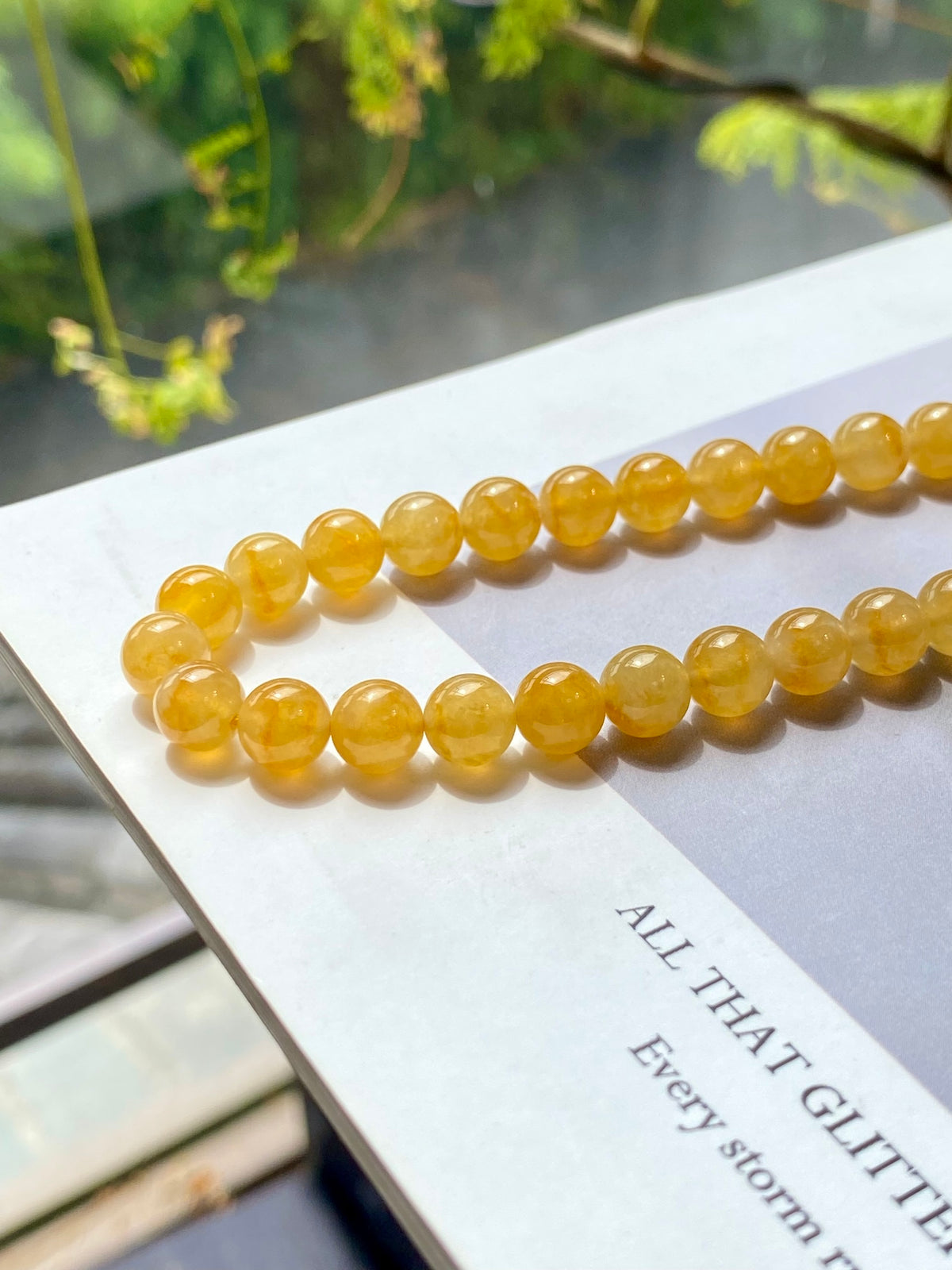 Golden-yellow round bead strand necklace on display card, side view