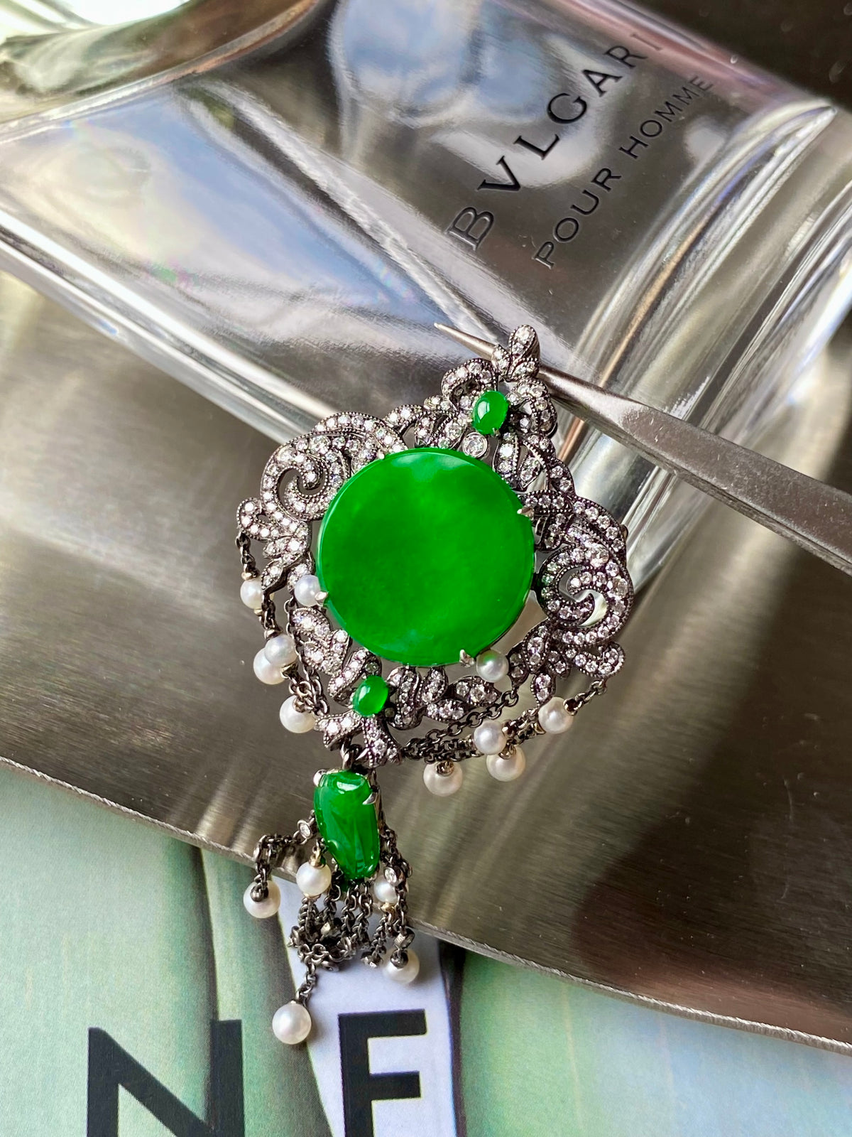 Round green jadeite brooch with swirling silver filigree and pearl fringe