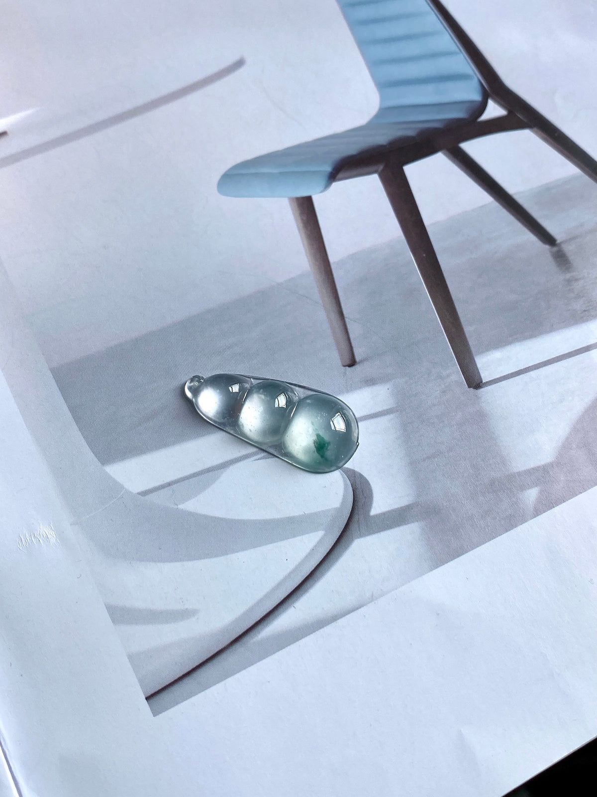 Green-flecked jadeite bean pendant in silver bezel, oval bean shape