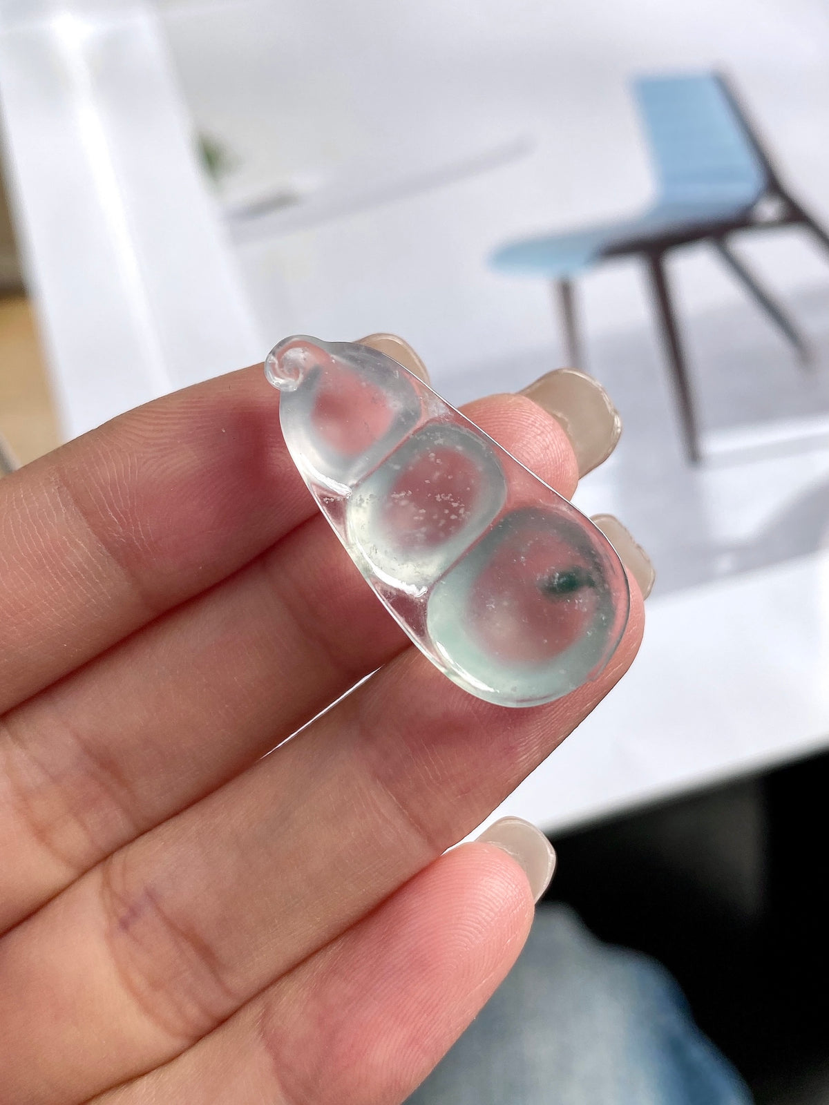 Translucent jadeite bean pendant in silver bezel, pink-red flecks visible