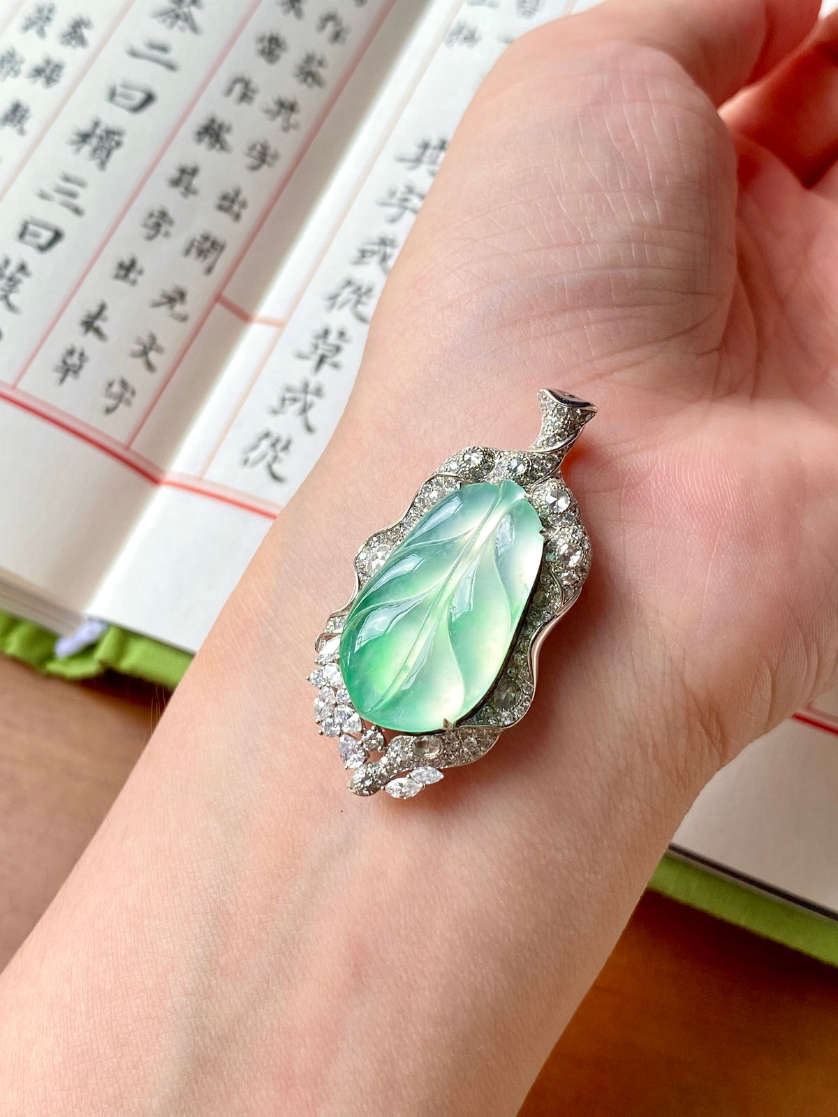 Silver-tone leaf pendant with icy green oval center and small clear sparkle stones