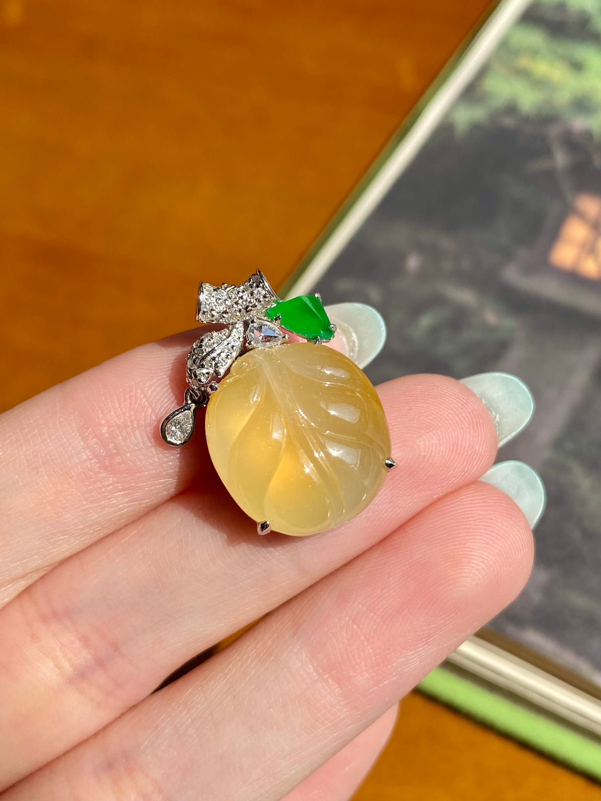 Jadeite leaf pendant: yellow oval cabochon, green leaf detail, silver setting with clear stones