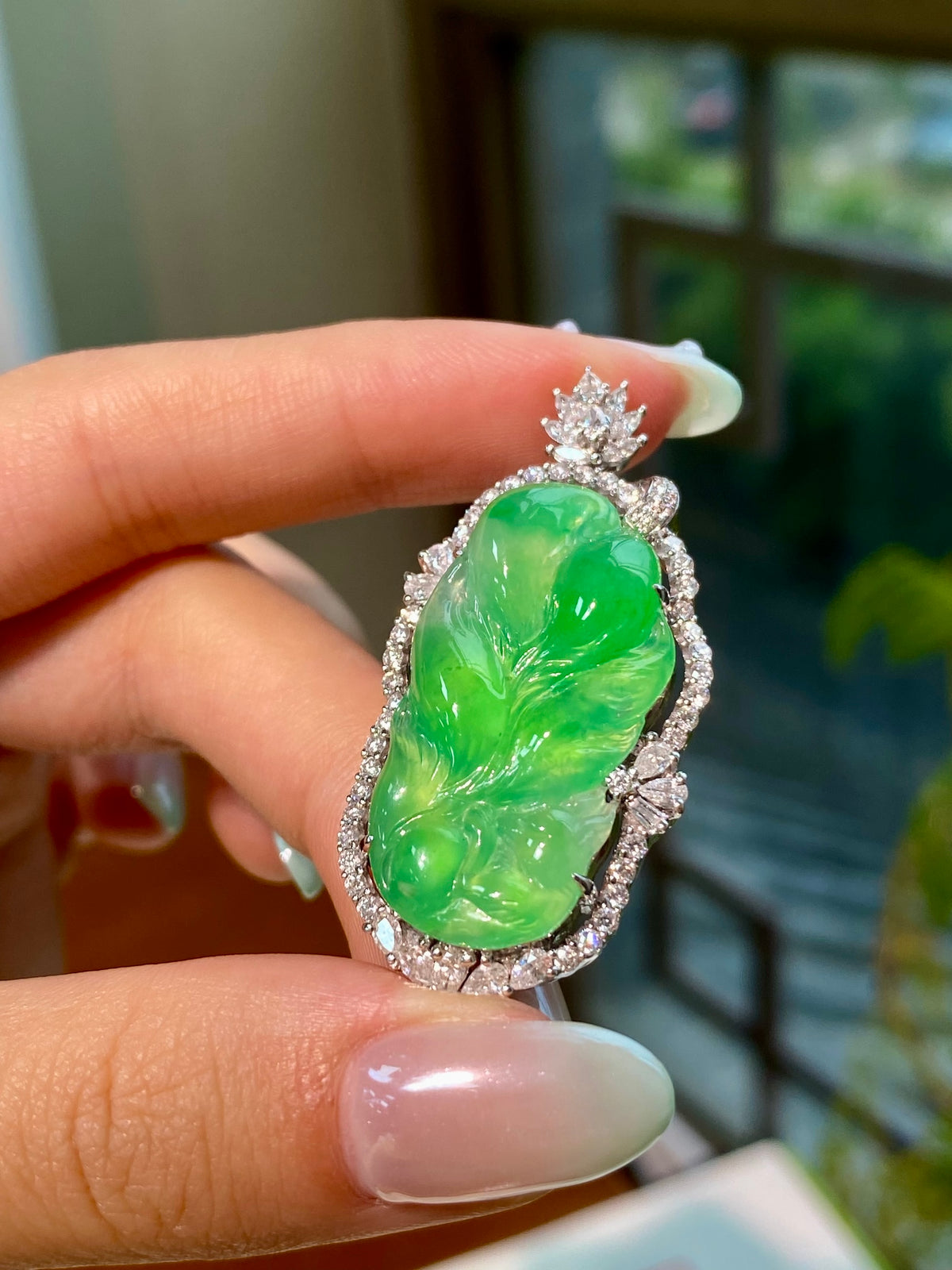 Green jadeite leaf pendant in ornate silver-tone frame with sparkly stones