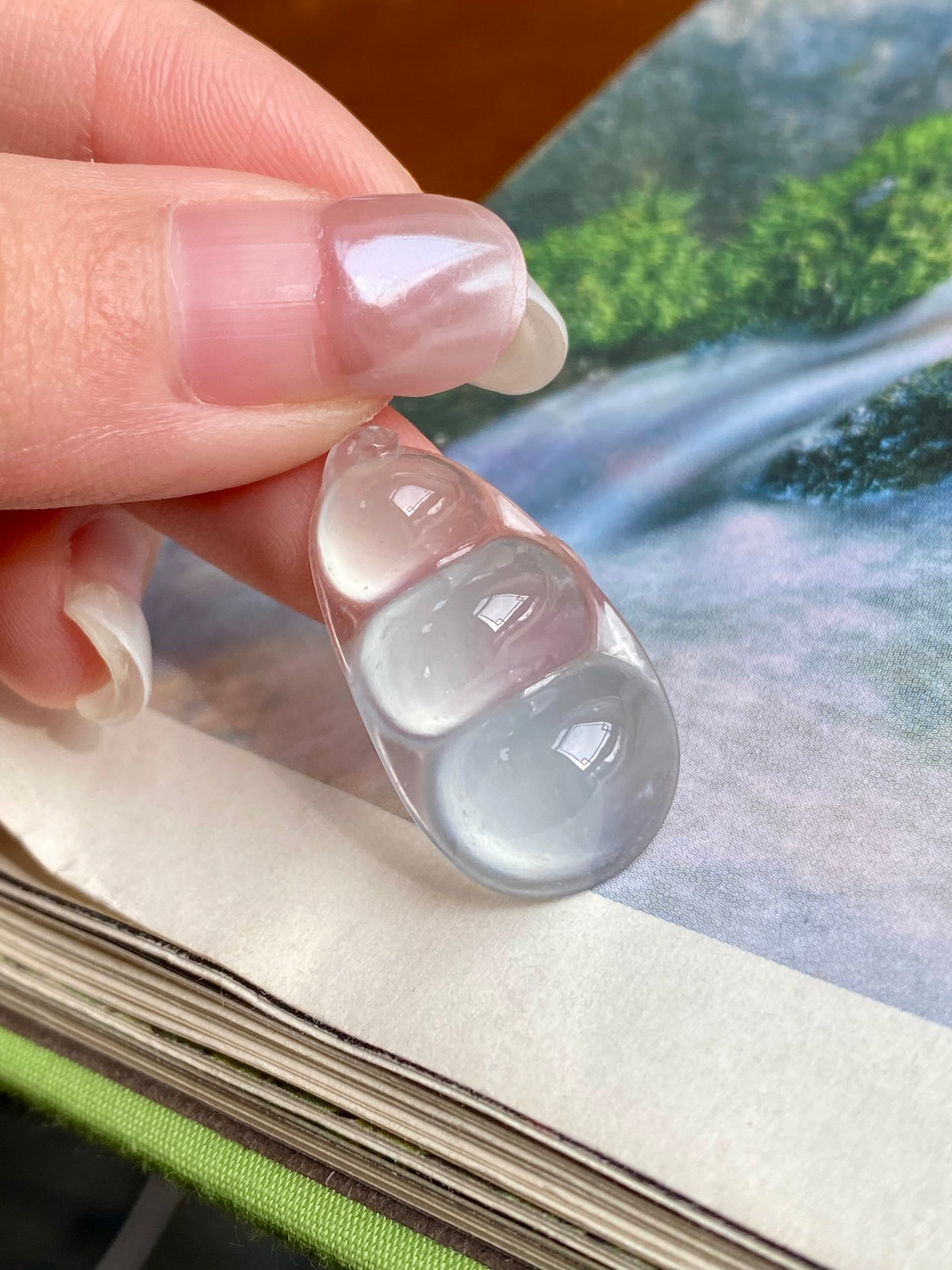 Jadeite bean pendant with milky white, translucent oval shape in unset setting