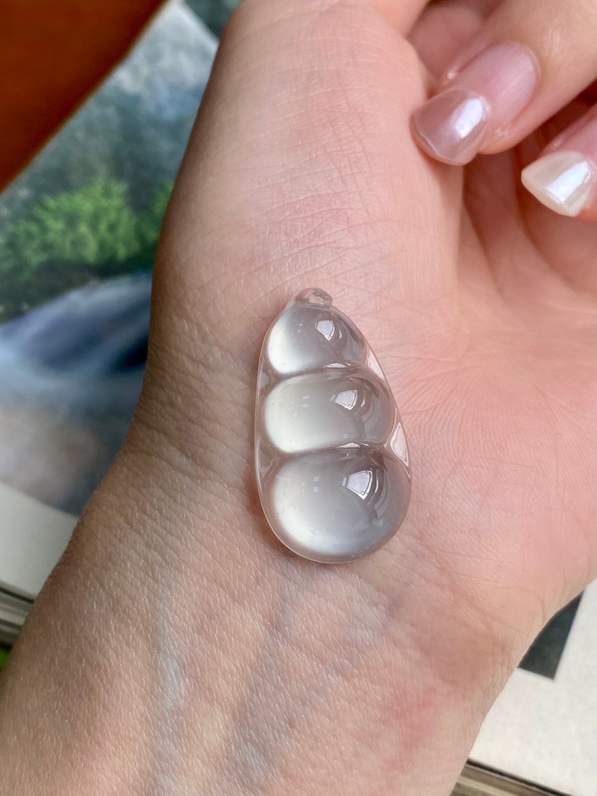 Unset jadeite bean pendant on palm, milky white translucent teardrop with rounded bumps