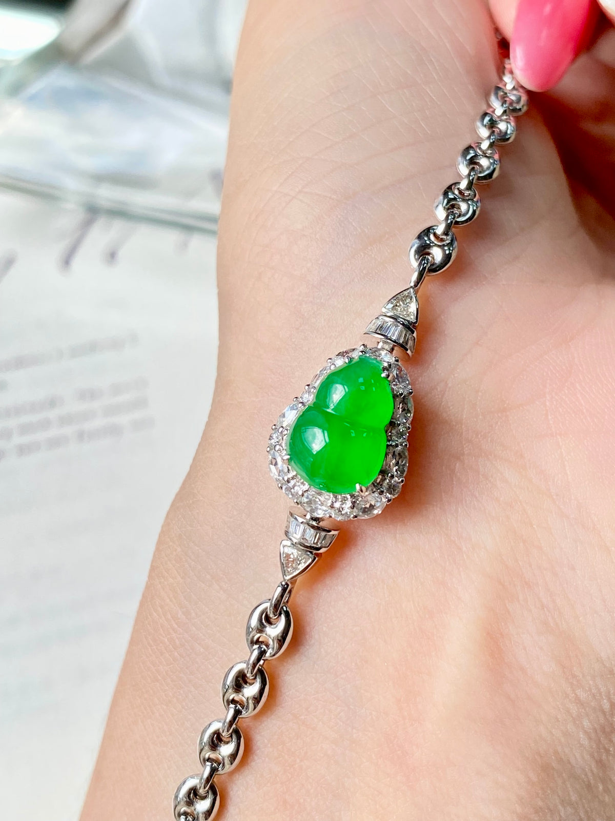 Green jadeite gourd charm bracelet on wrist with silver-toned chain and clasp