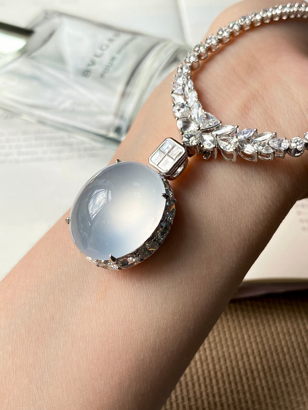 Silver-tone rhinestone tennis necklace with oval light-blue cabochon pendant