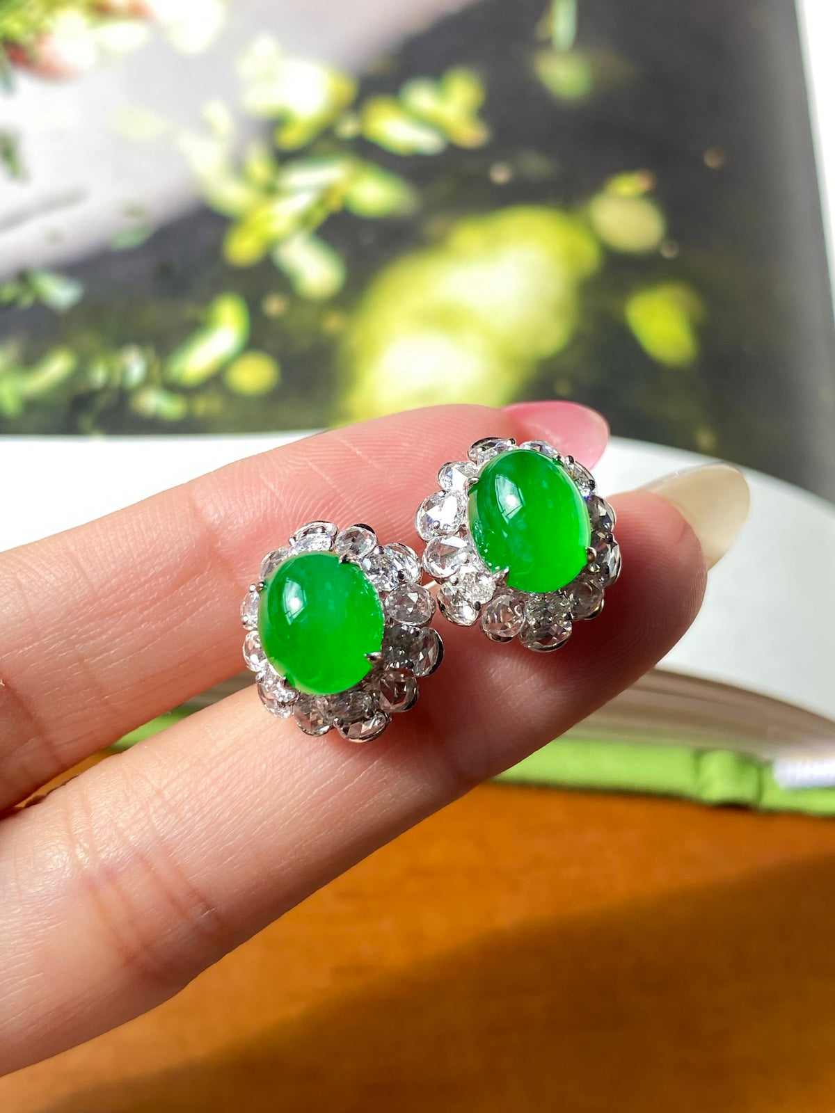 Green jade cabochon studs with silver floral filigree and tiny clear crystals, on hand