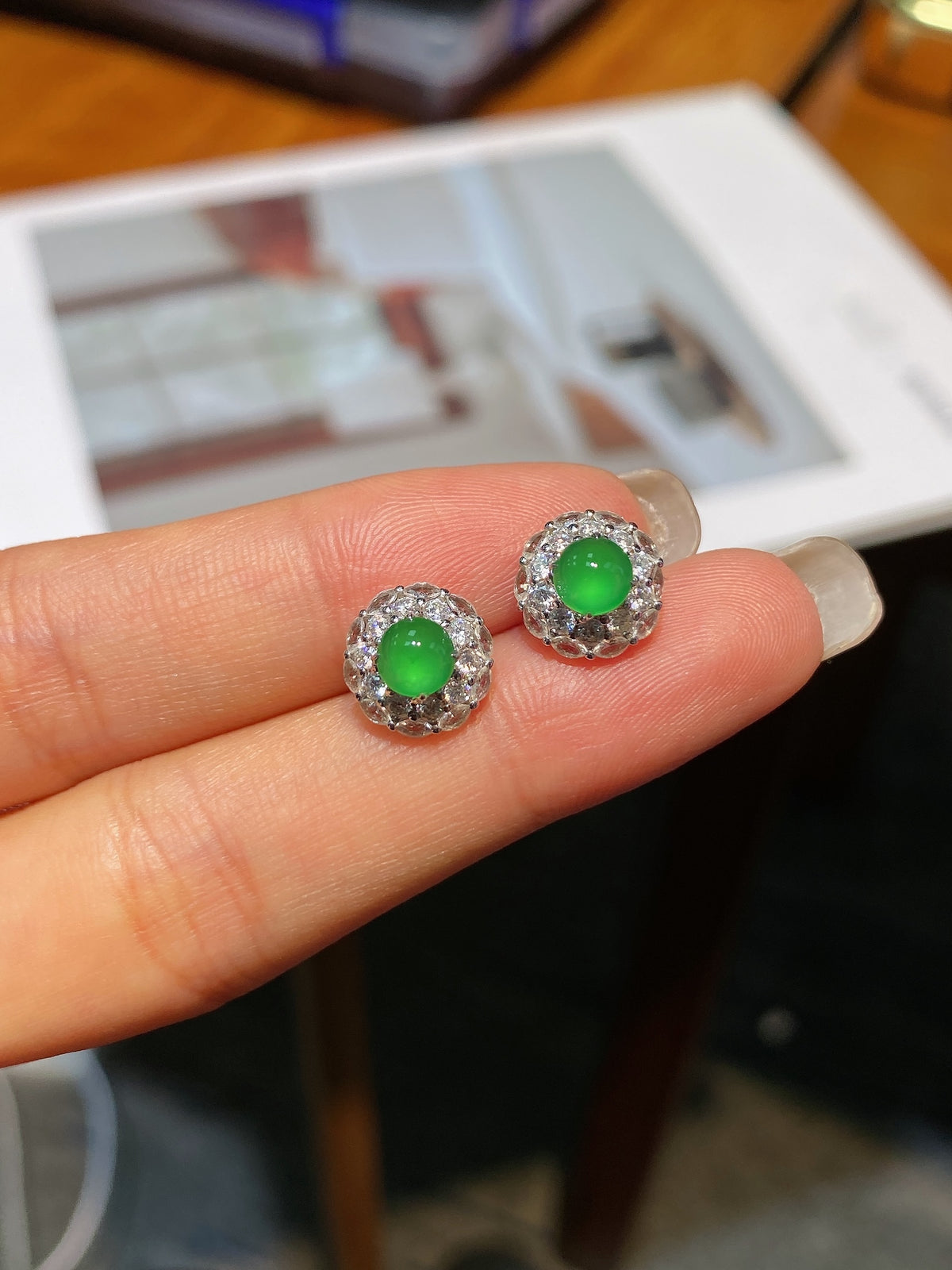 Jadeite cabochon stud earrings with green center stones and halo settings