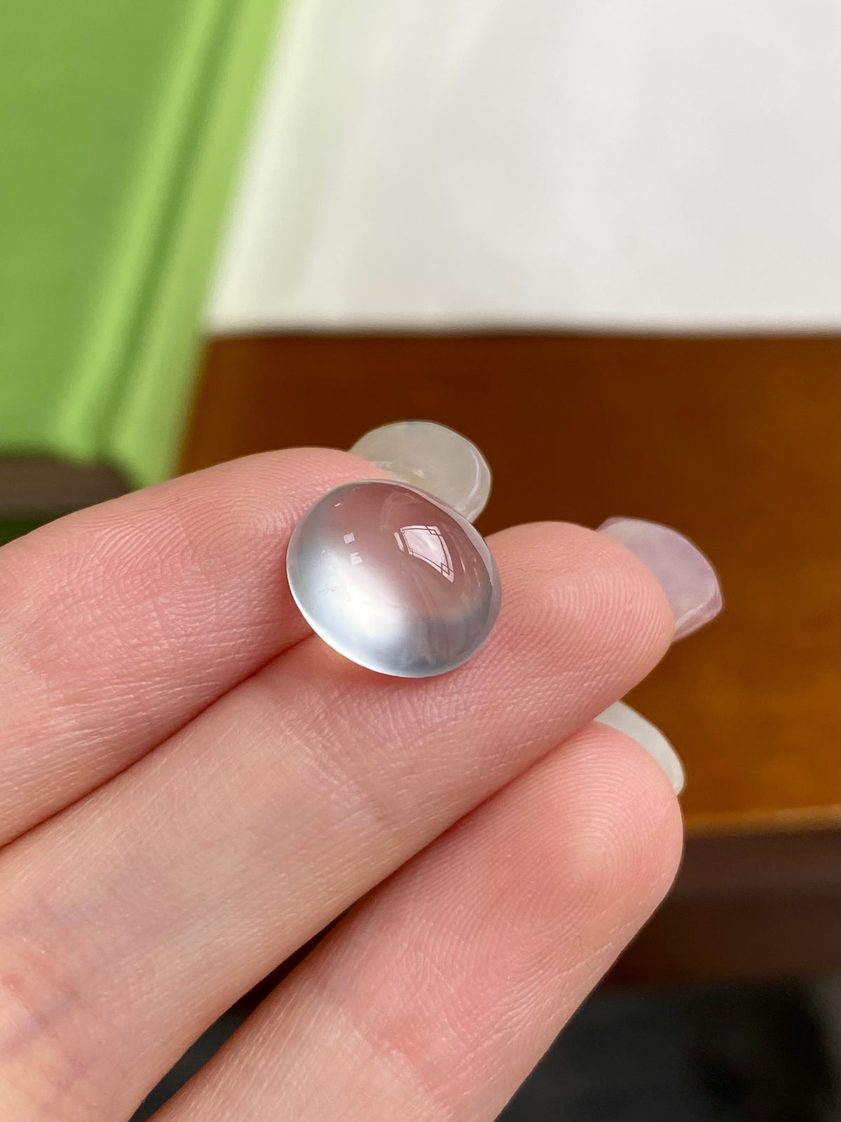 Jadeite cabochon loose stone, domed translucent white on hand