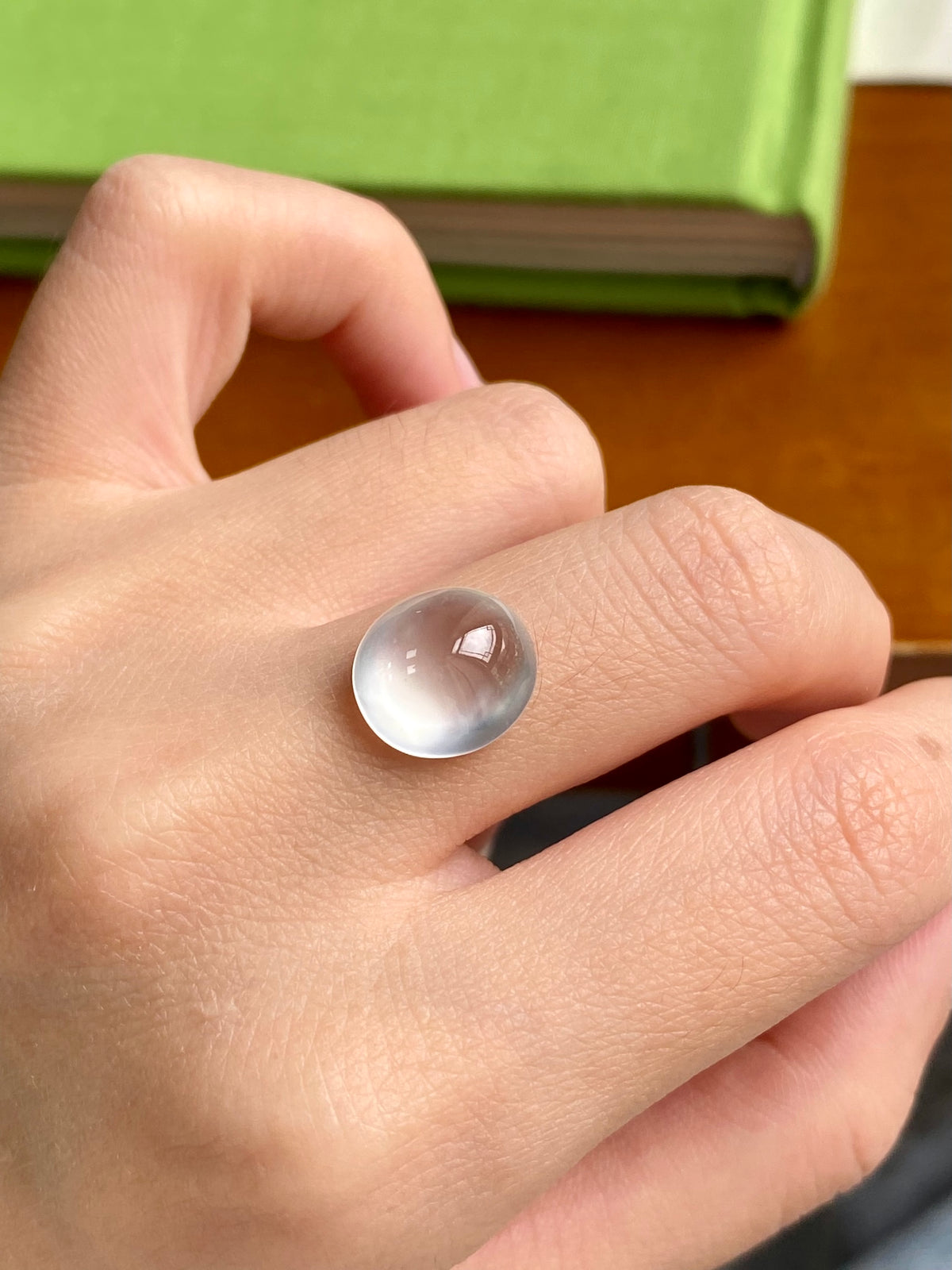 Jadeite cabochon loose stone, small domed translucent white on finger