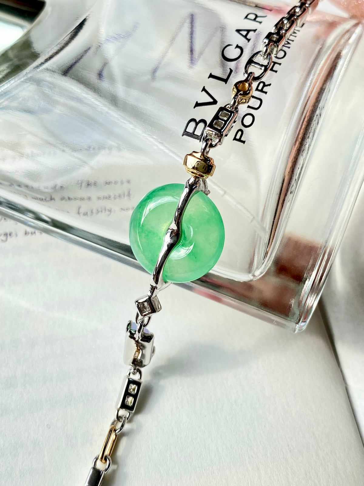 Green jade donut bracelet with teardrop-like setting and silver charm links