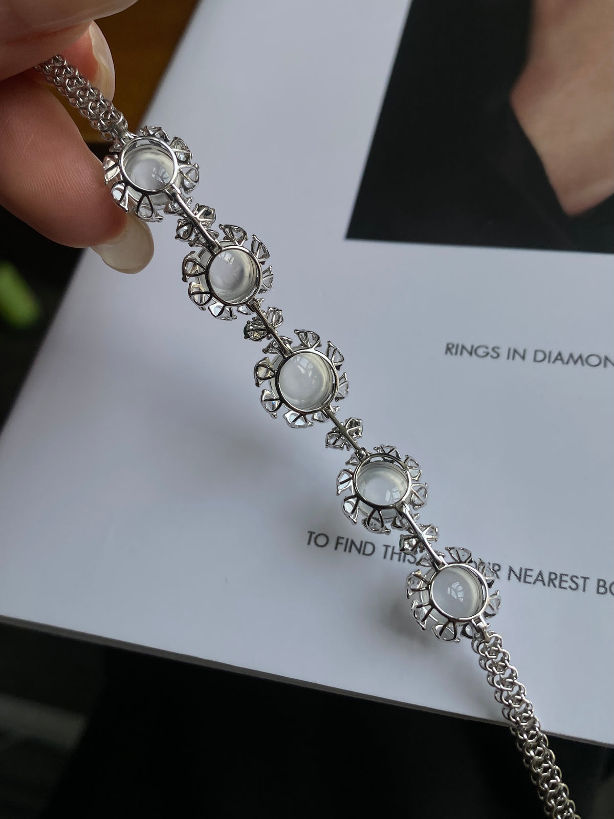 Oval cabochon bracelet detail with white stones in ornate bezels along silver chain