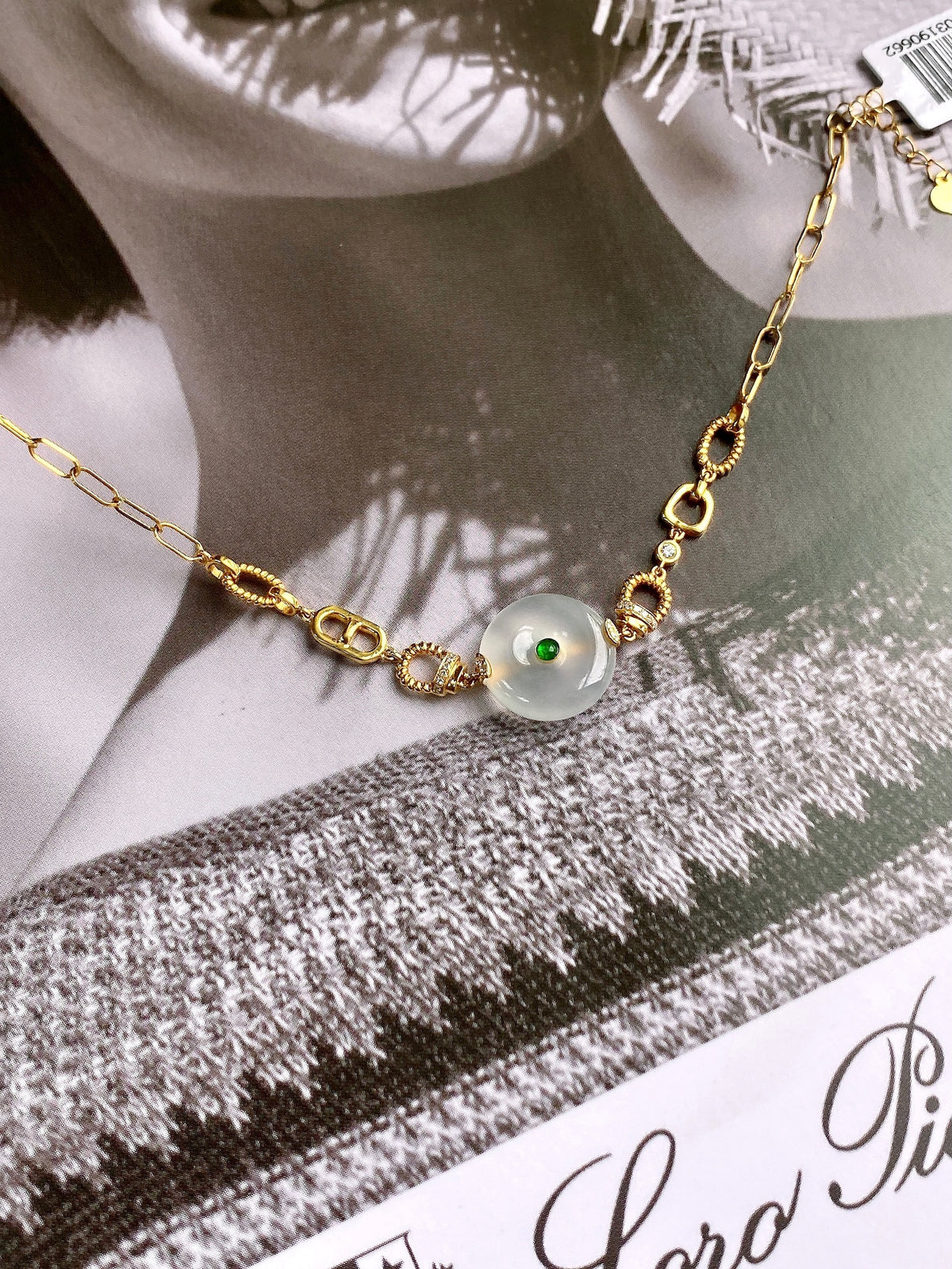 Gold safety-disc bracelet on card with white disc bead and green center