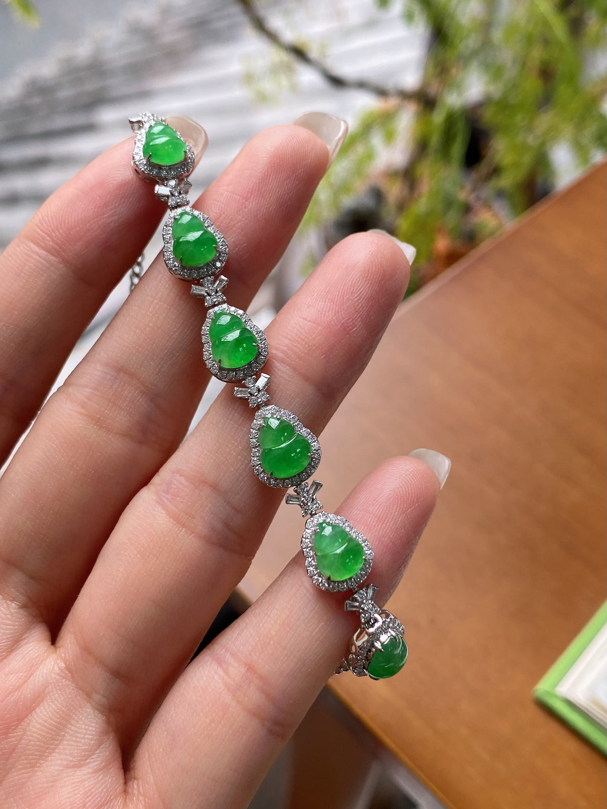 Green jadeite oval cabochon bracelet in hand with silver-toned prong settings