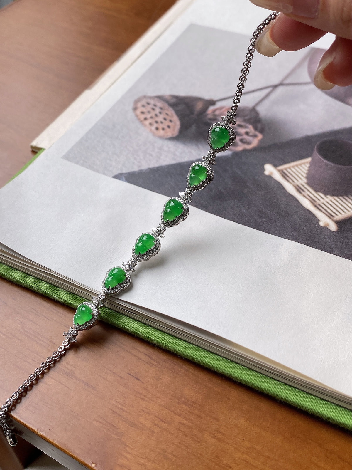 Green jadeite bracelet with oval cabochons and silver-toned chain links on display card