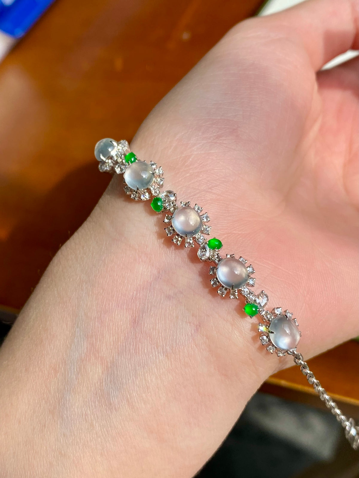 Jadeite cabochon bracelet close-up with oval white stones, green beads, and rhinestone accents