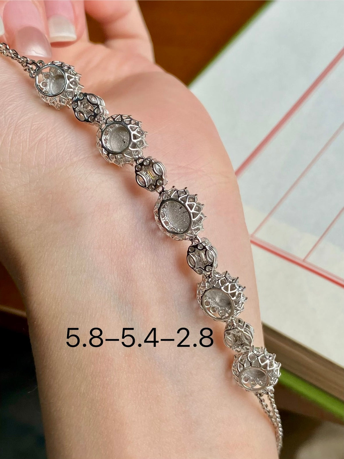 Silver-tone charm-style bracelet with green oval cabochon centers and ornate links
