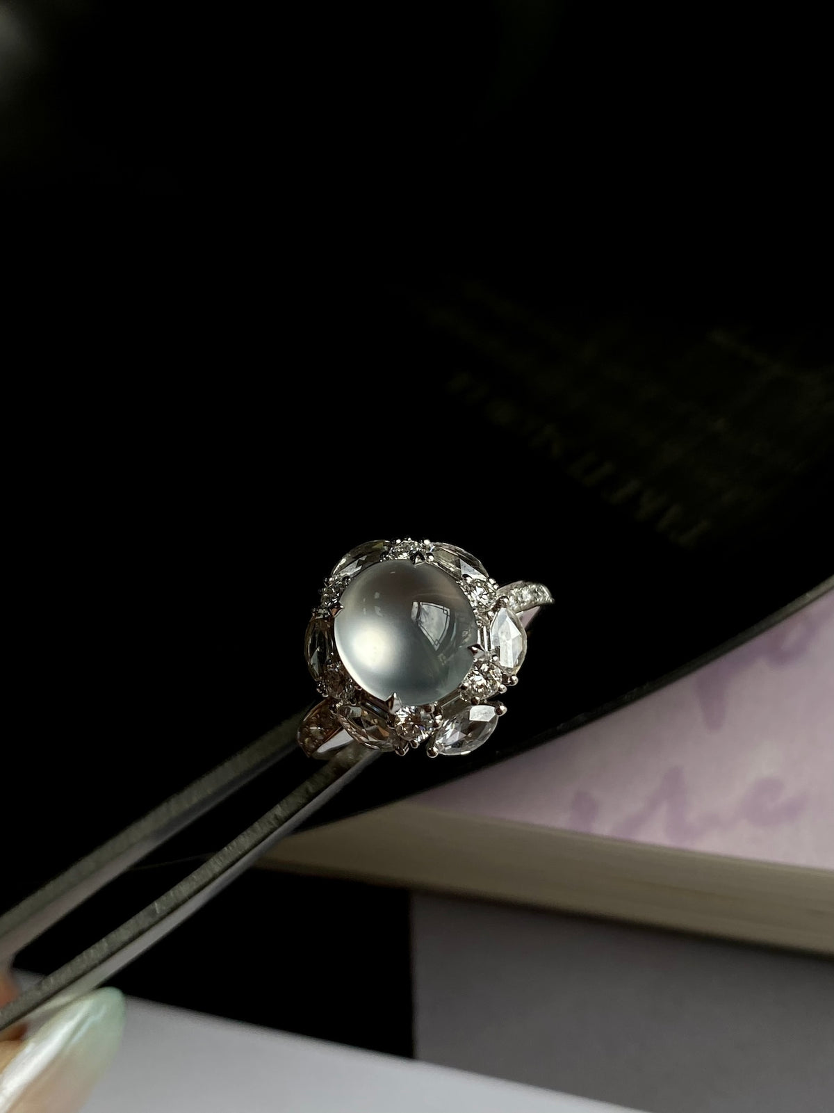 Silver-tone oval cabochon ring with halo and prong-set side detail