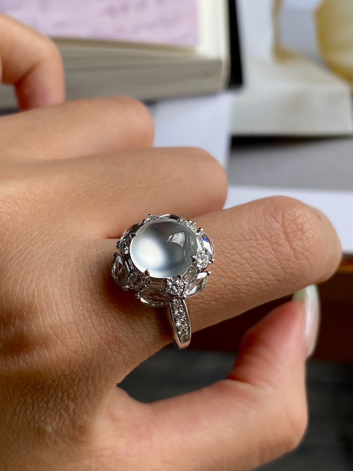 Silver-tone ring with oval cabochon center stone and detailed halo