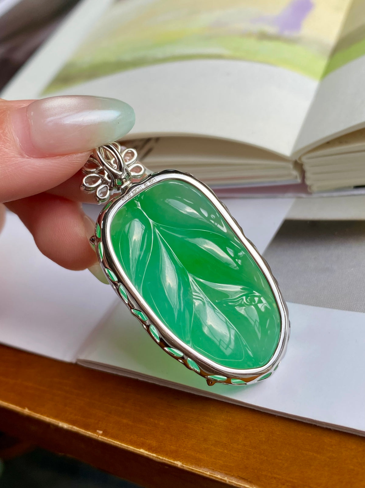Green jadeite leaf pendant with silver-tone frame and crystal cluster bail
