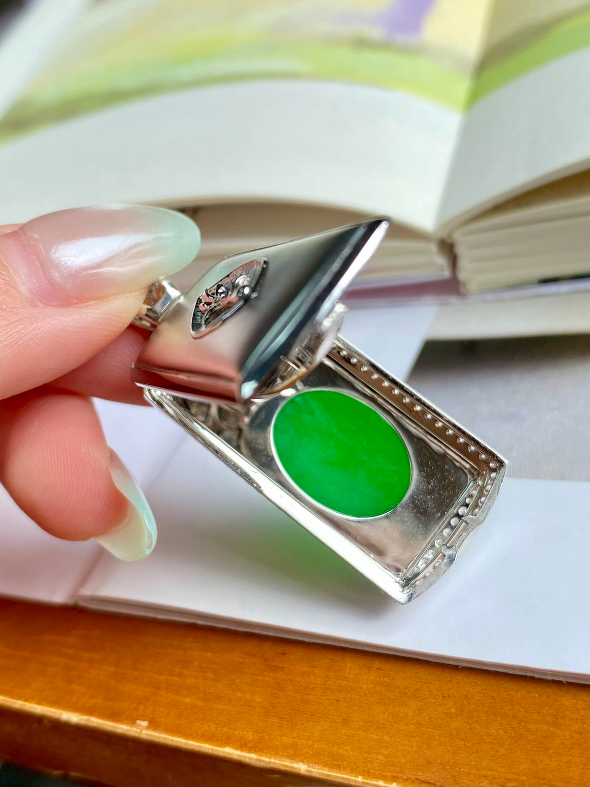 Green jadeite oval centerpiece pendant with silver border and diamond-like detailing