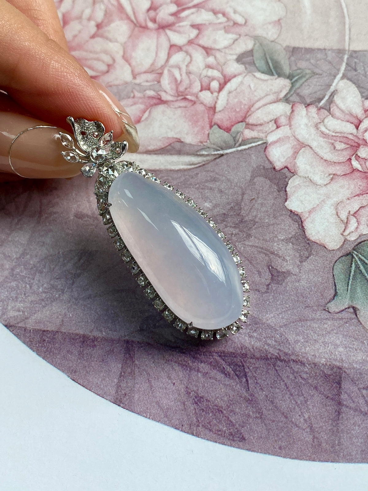 Oval lavender gemstone pendant with floral top detail and dark beaded border, silver