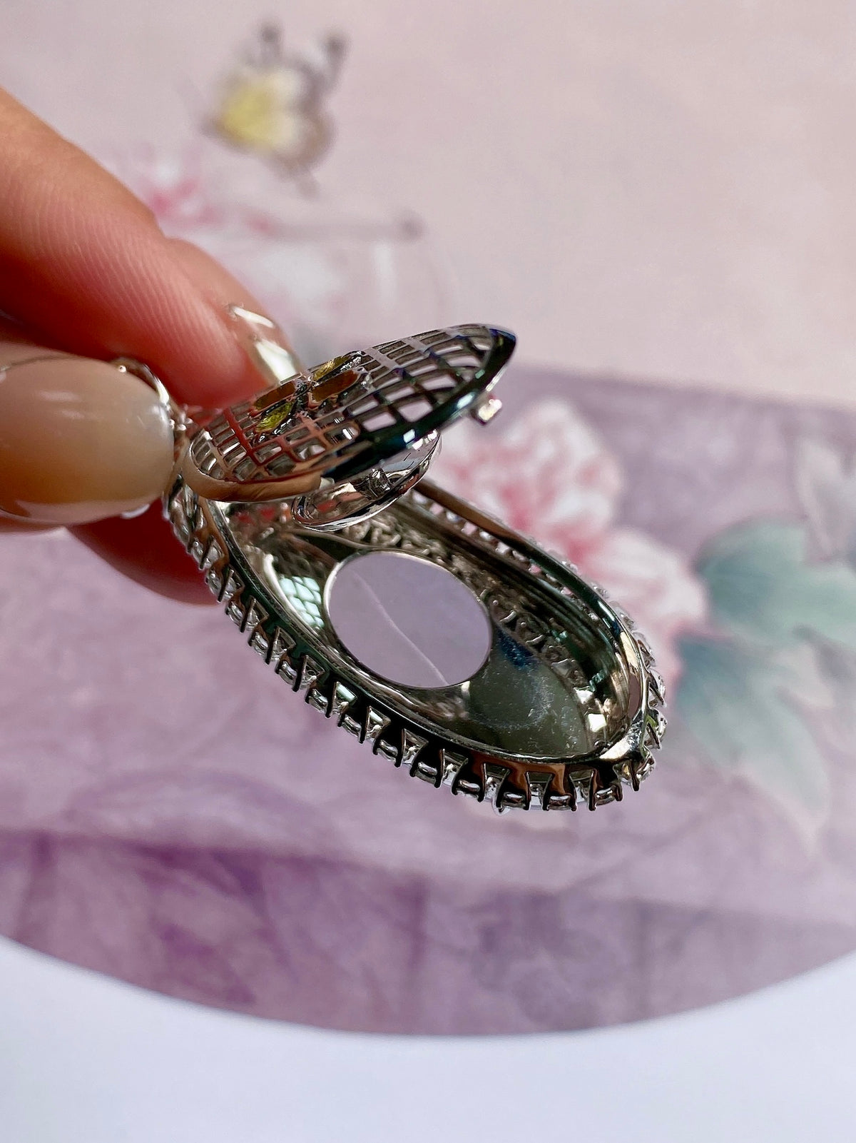 Oval lavender gemstone pendant with beaded halo and floral top, silver-tone