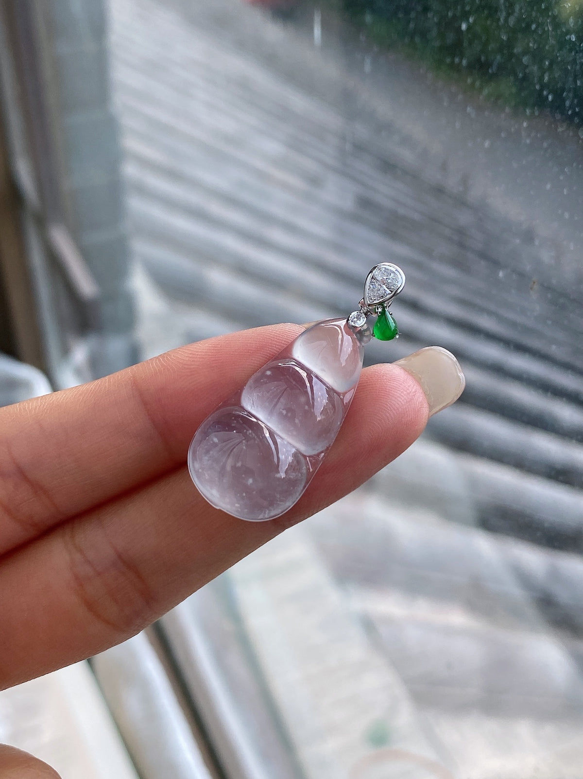 Icy white jadeite pea pod pendant with green teardrop accent and silver loop