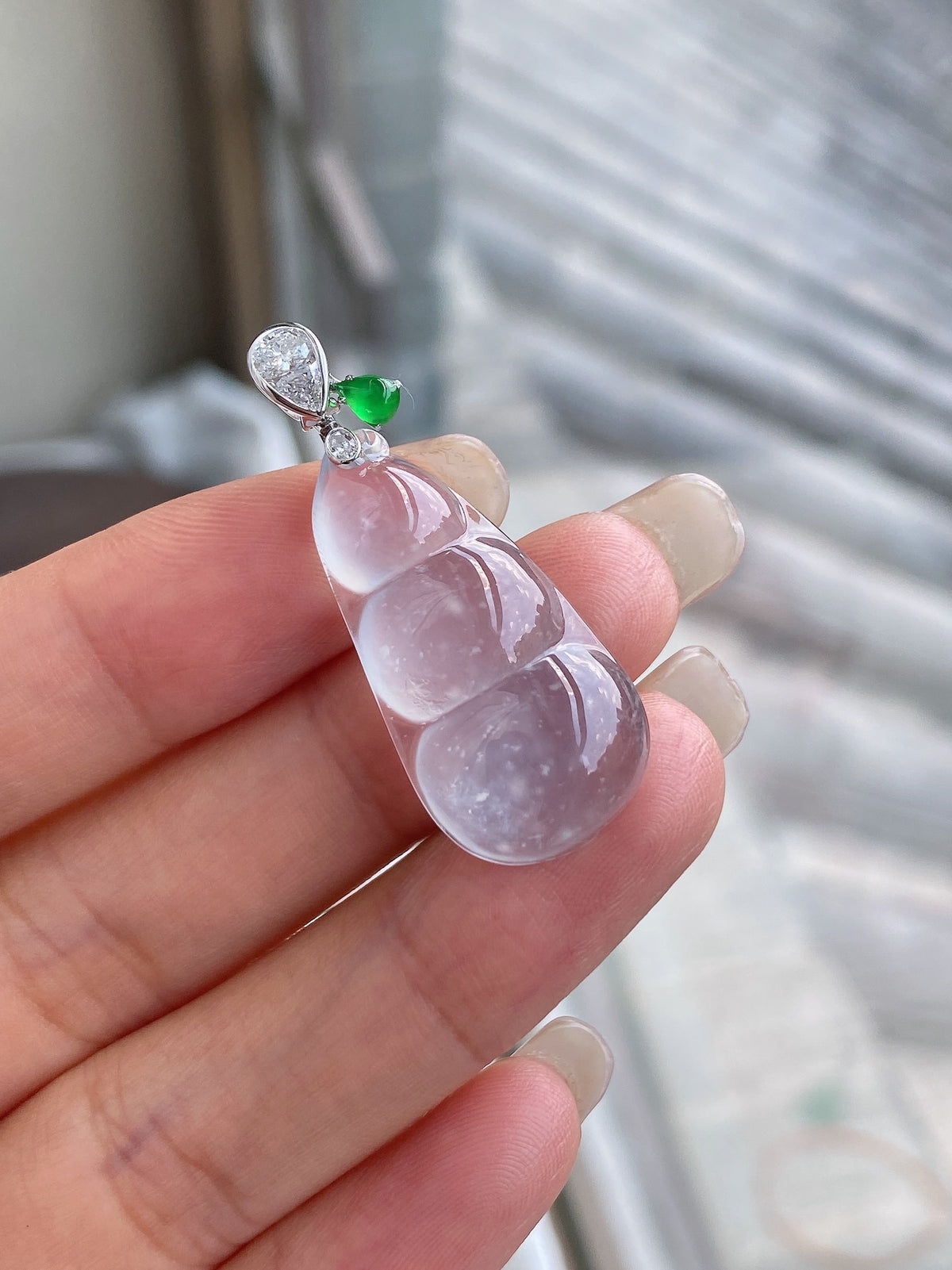 Icy white jadeite pea pod pendant with green accent and detailed silver top setting