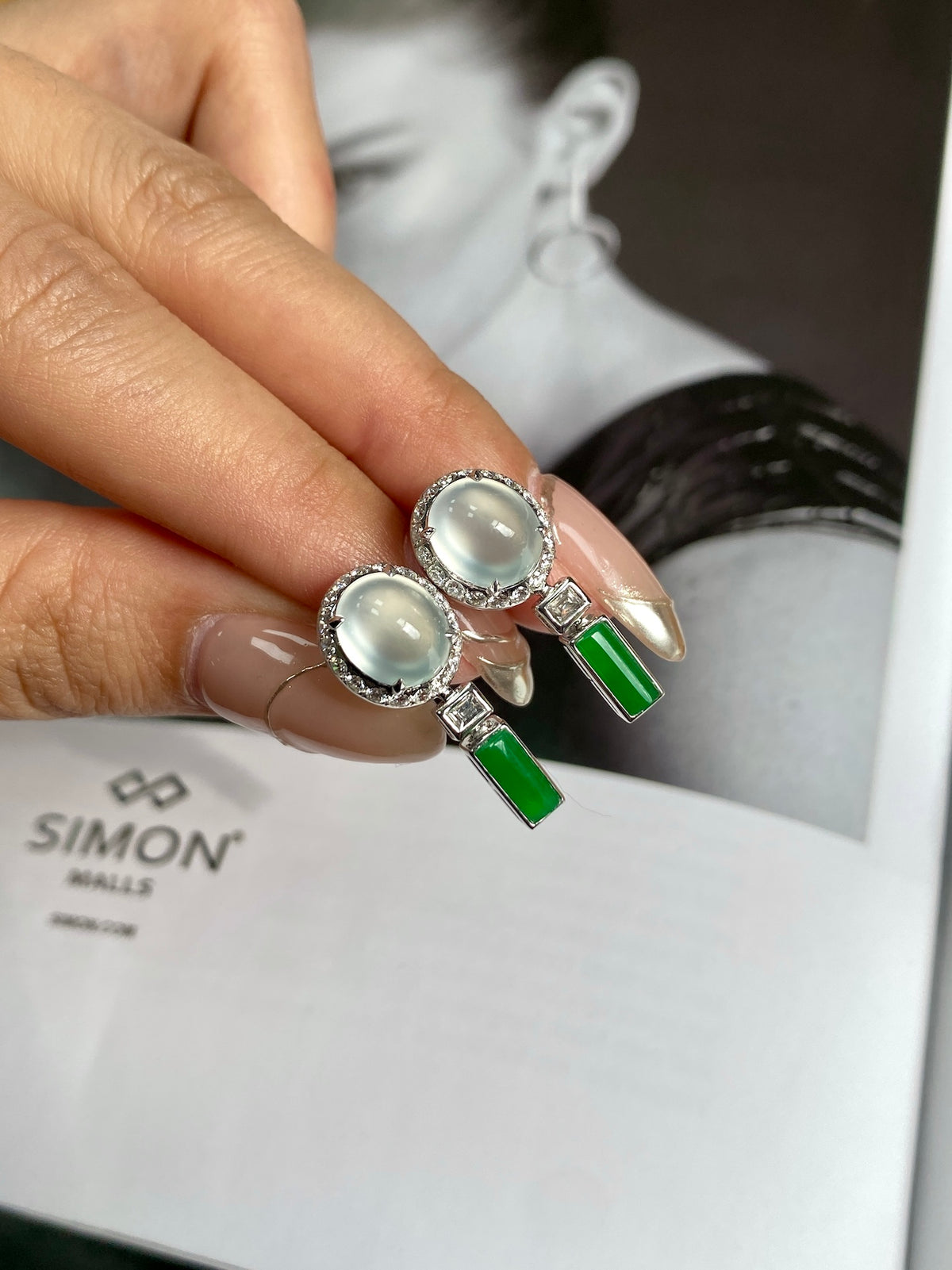 Pair of round white cabochon stud earrings with green bar drops and silver settings