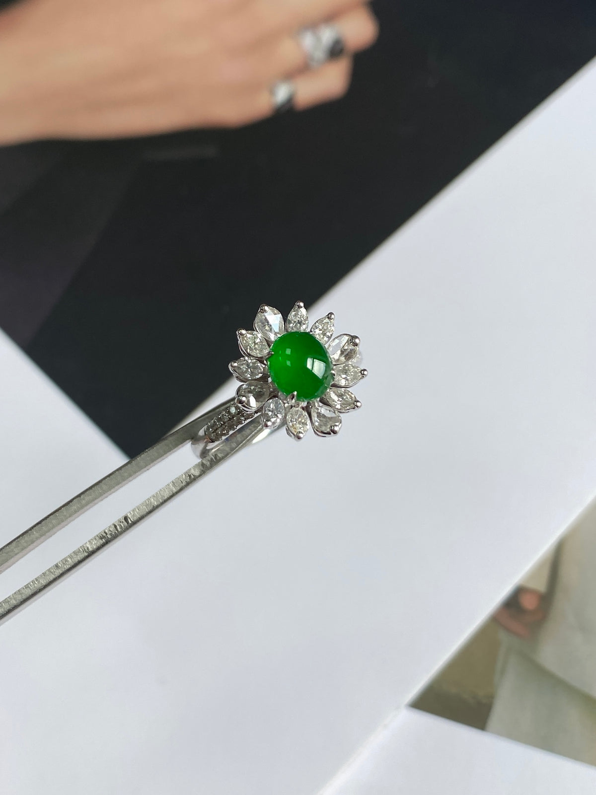 Detail view of silver ring with round green jadeite cabochon and sparkling halo