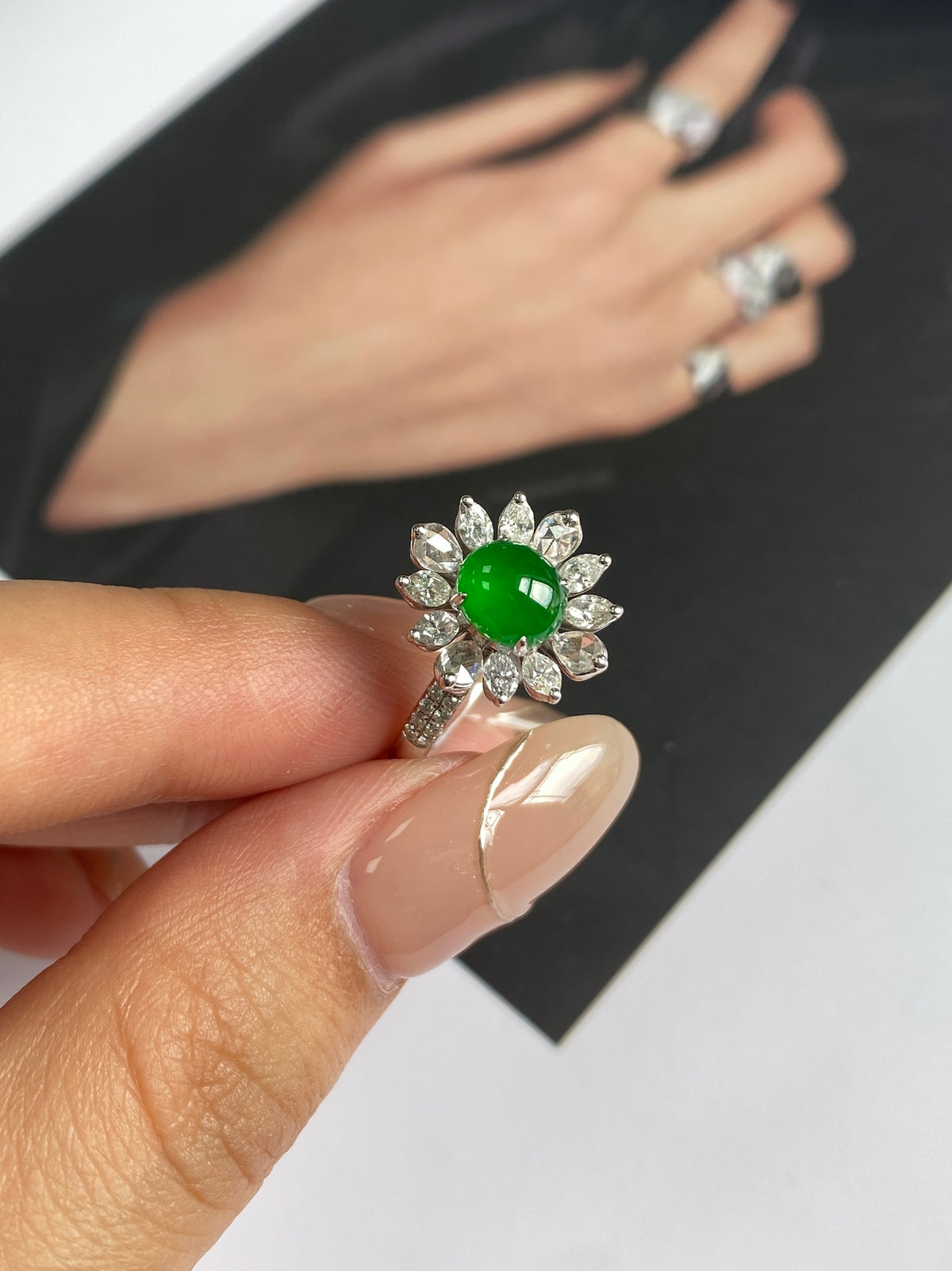 Green jadeite cabochon cocktail ring on finger with diamond-like flower setting