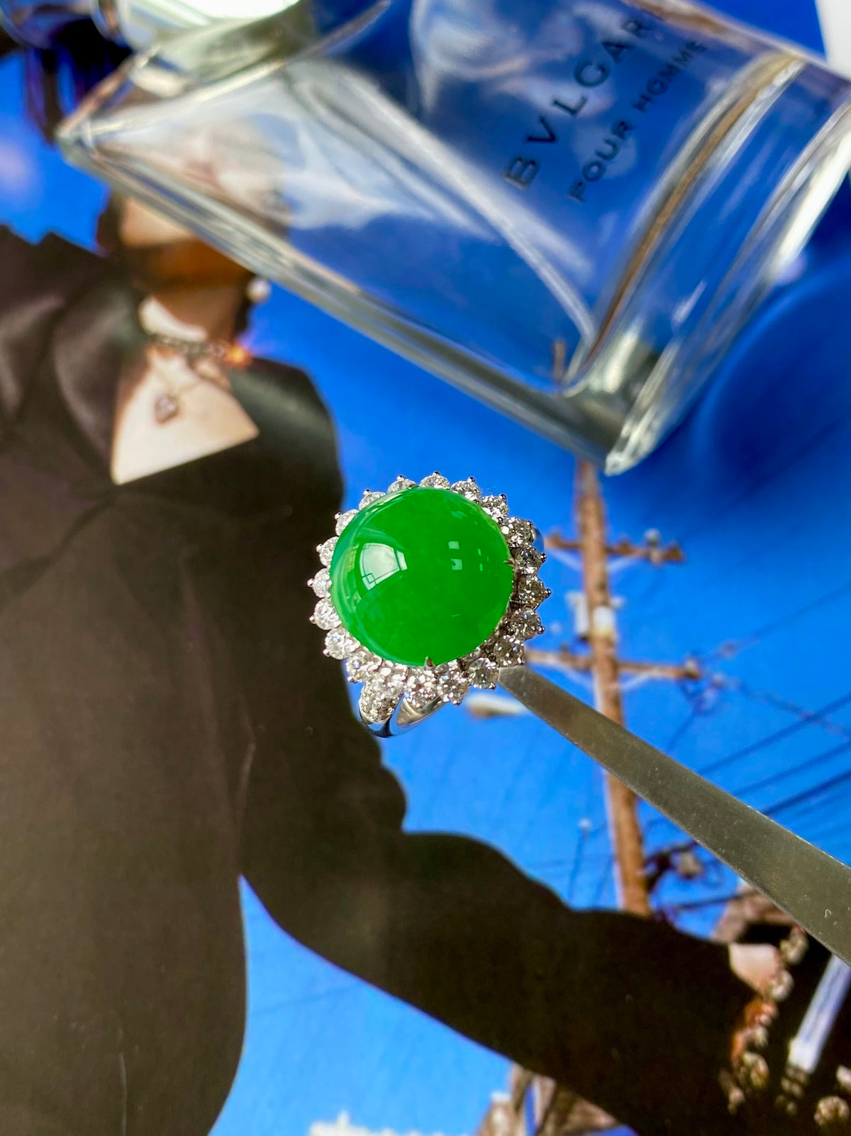Green jadeite cabochon ring with bright emerald-green center and diamond halo