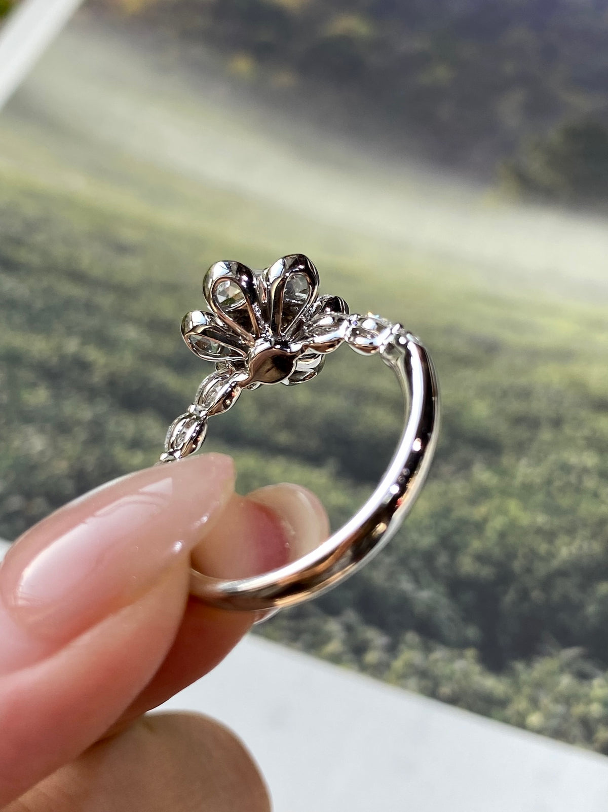 Silver-tone ring with round light gray-white cabochon and clustered crystal leaf prongs