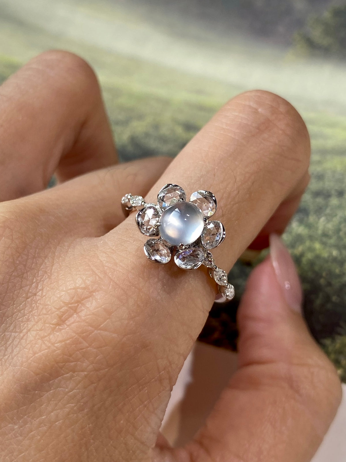 Light gray-white cabochon ring with marquise and round crystal halo, openwork shank