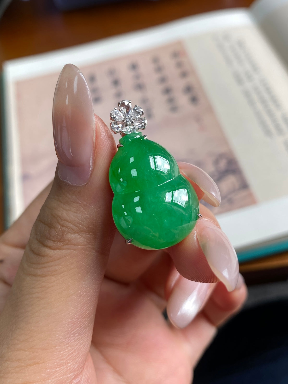 Green gourd jade pendant with silver setting and sparkling cluster above