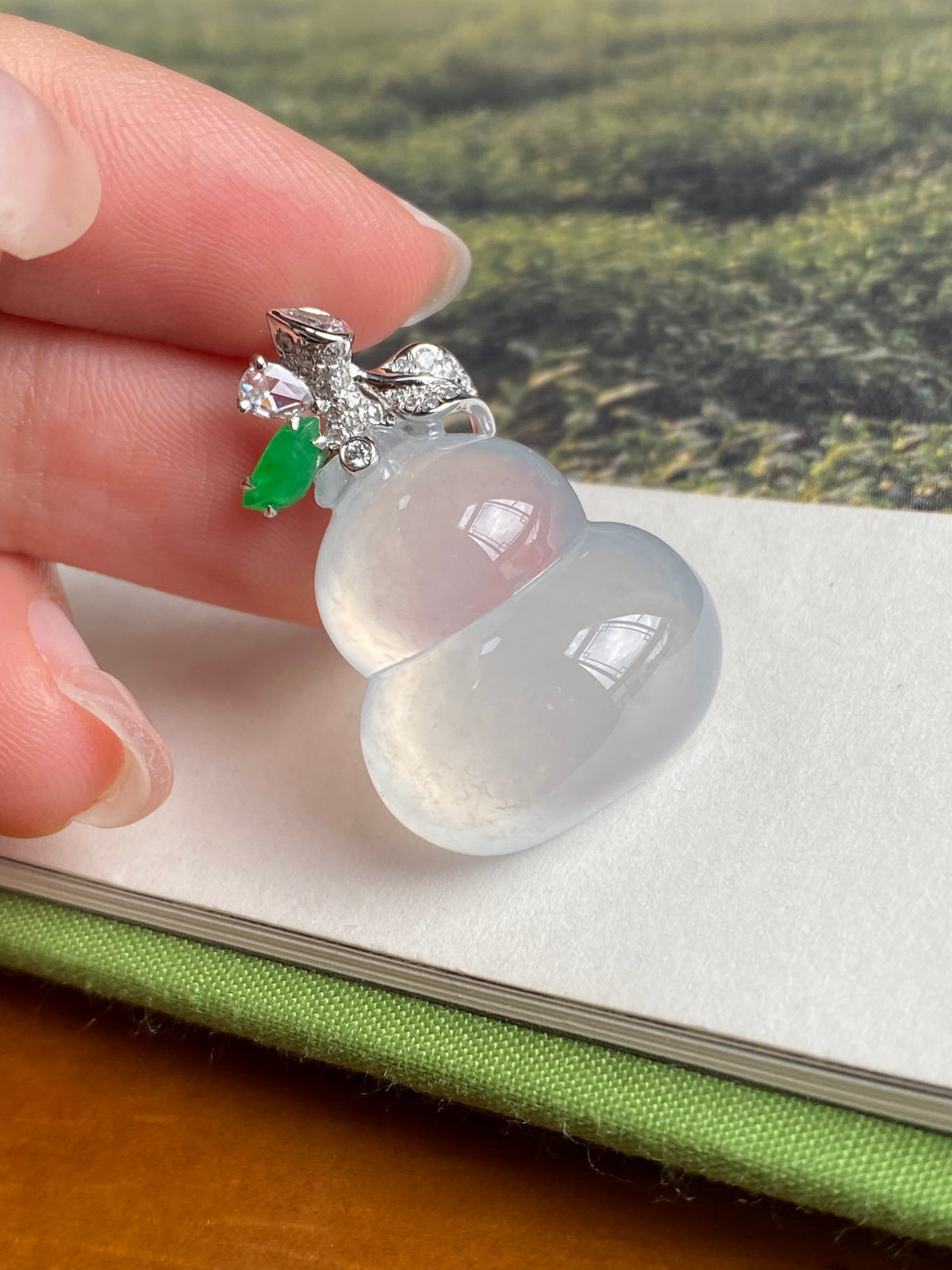 Icy white jade gourd pendant with silver-tone prong top, green leaf accent, clear gems