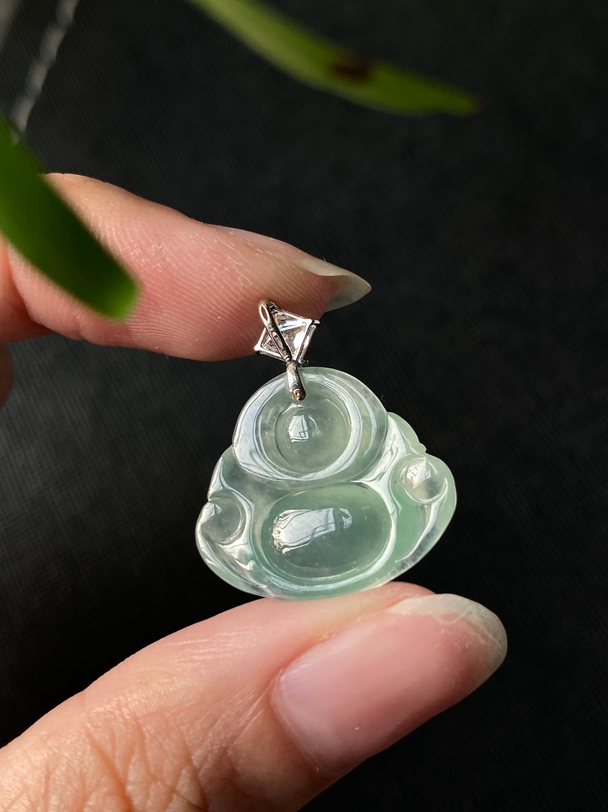 Green jadeite Laughing Buddha pendant front view in silver bezel with clear top stone