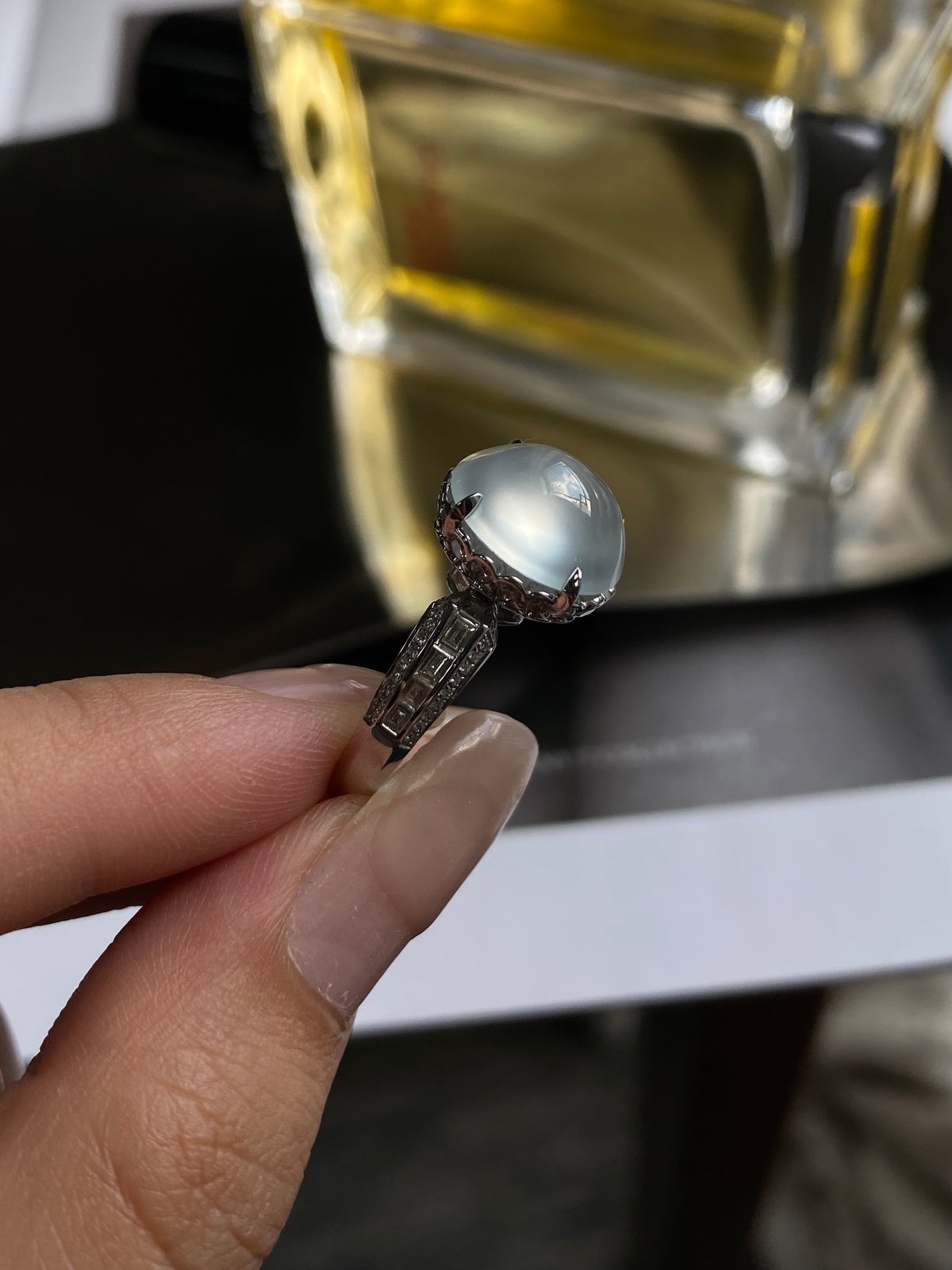 White jadeite cabochon ring featuring round pale cabochon and dark marquise-pattern band
