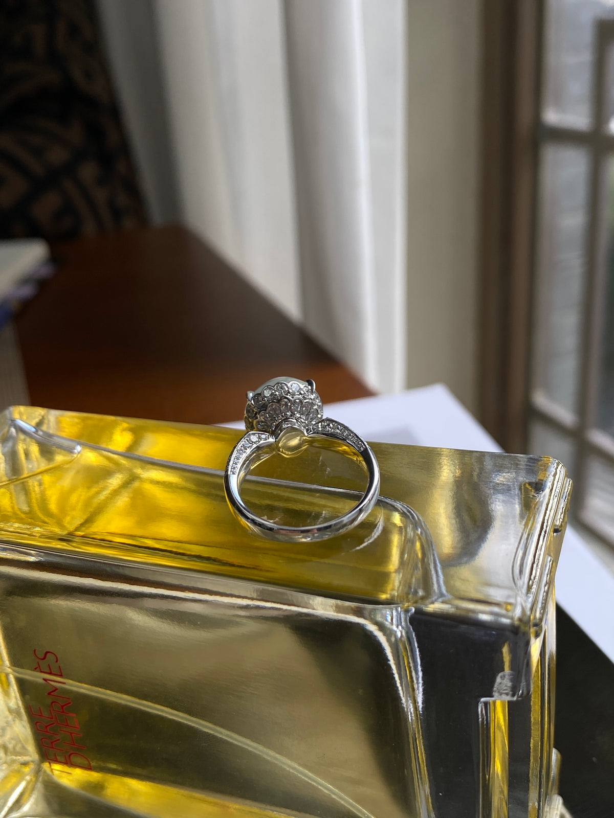 White cabochon ring on display stand, round pale stone with dark band